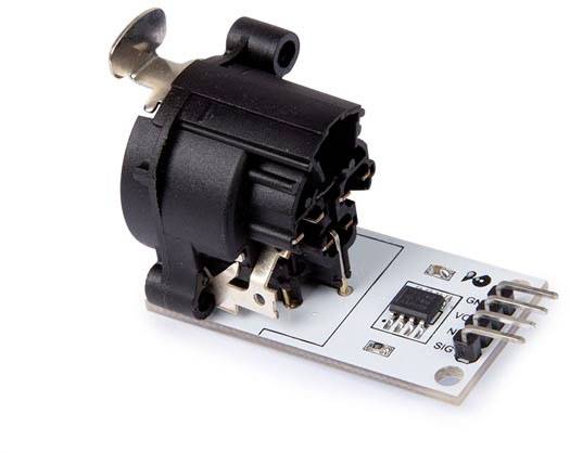 Un capteur électromagnétique noir sur une carte électronique blanche avec plusieurs contacts de connexion, présenté sur un fond blanc.