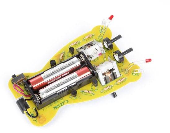 Voiture jouet électronique sans boîtier, montrant le circuit interne avec deux batteries et des LED sur une carte électronique jaune.