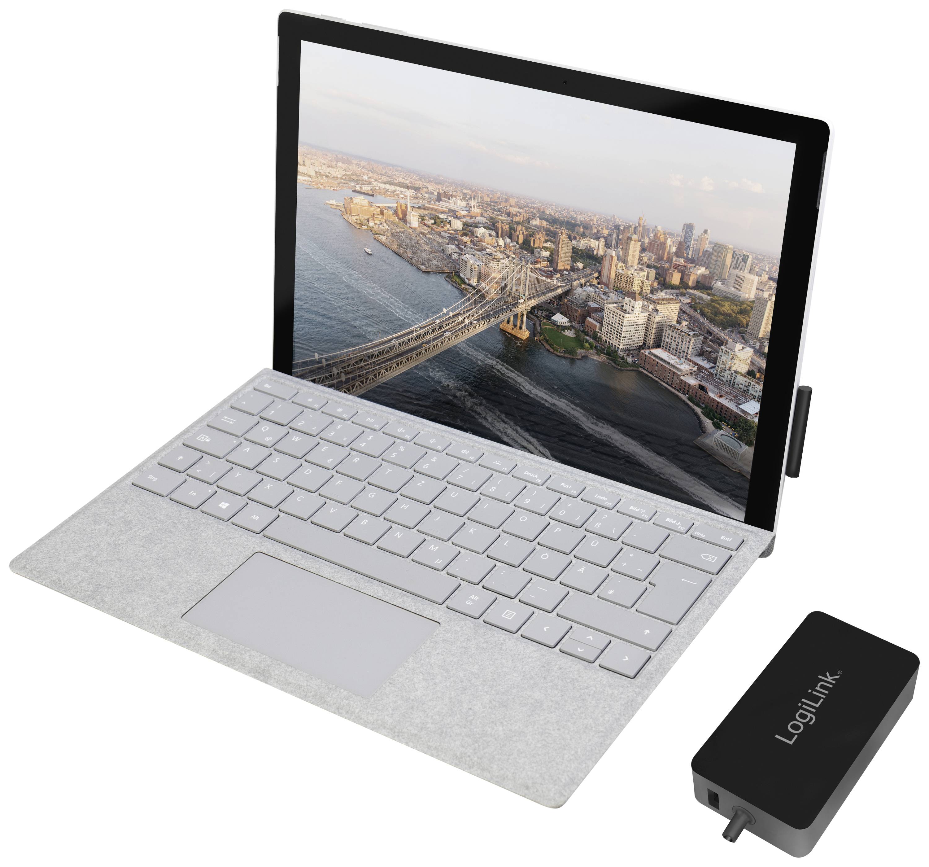 Un ordinateur portable avec une image de New York à l'écran et un chargeur LogiLink à côté.