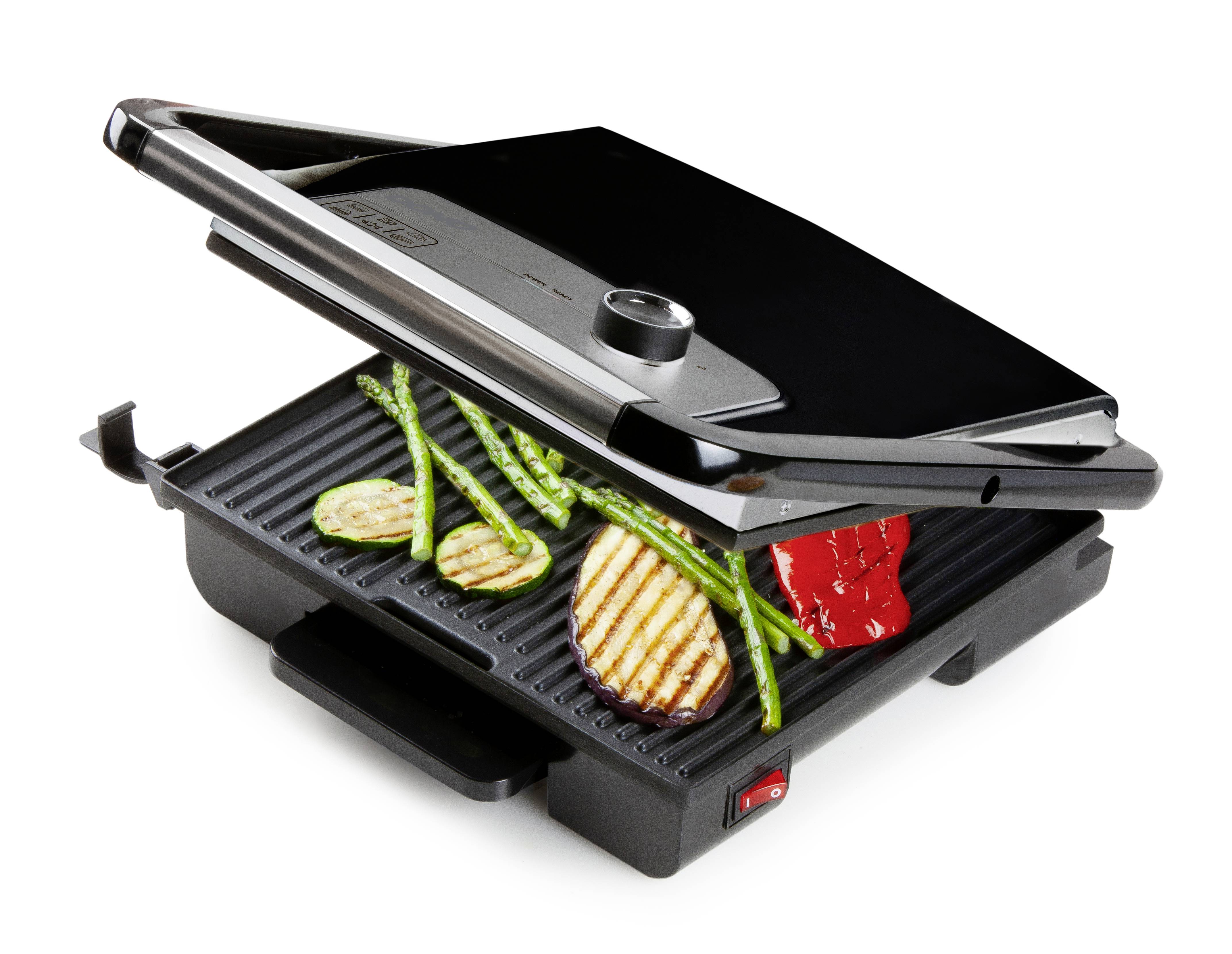 Un grill de table ouvert avec des légumes grillés et un filet de poulet. La plaque de grill présente des courgettes, des asperges, des poivrons et du poulet.