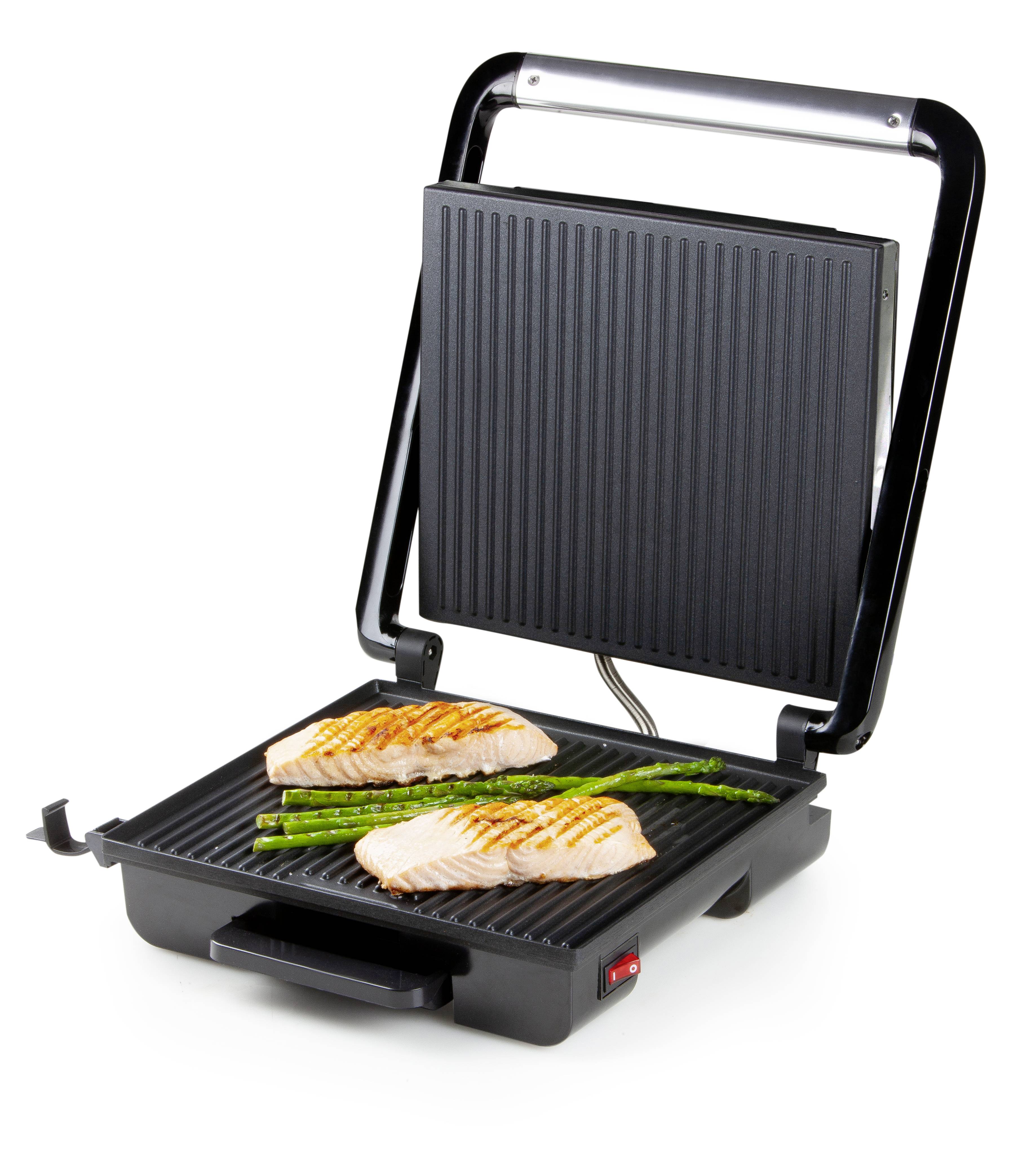 Grill de table électrique avec la plaque de cuisson dépliée. Deux morceaux de saumon et des asperges y sont en train de griller.