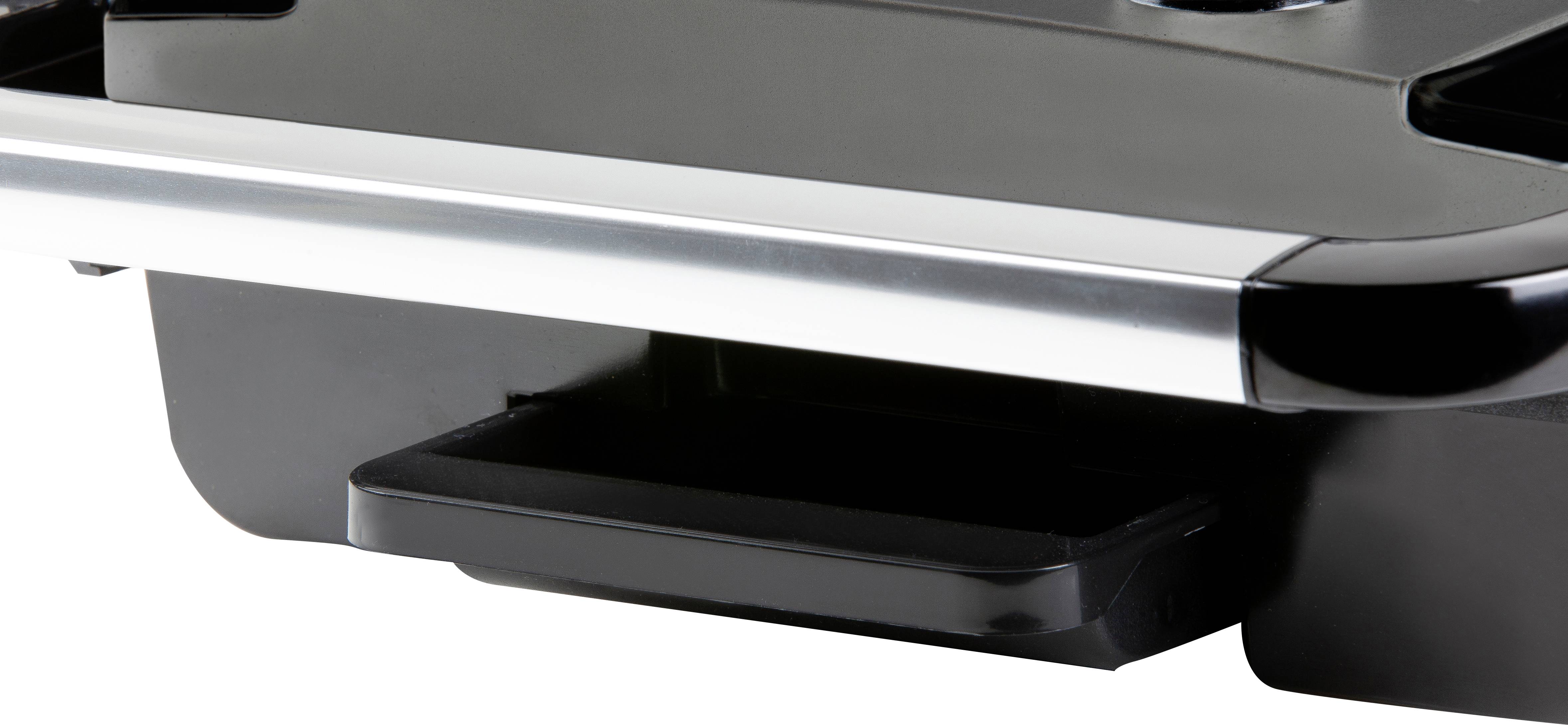 Appareil noir avec bordure argentée et tiroir proéminent sur sa face inférieure, probablement un composant électronique ou une partie de machine.