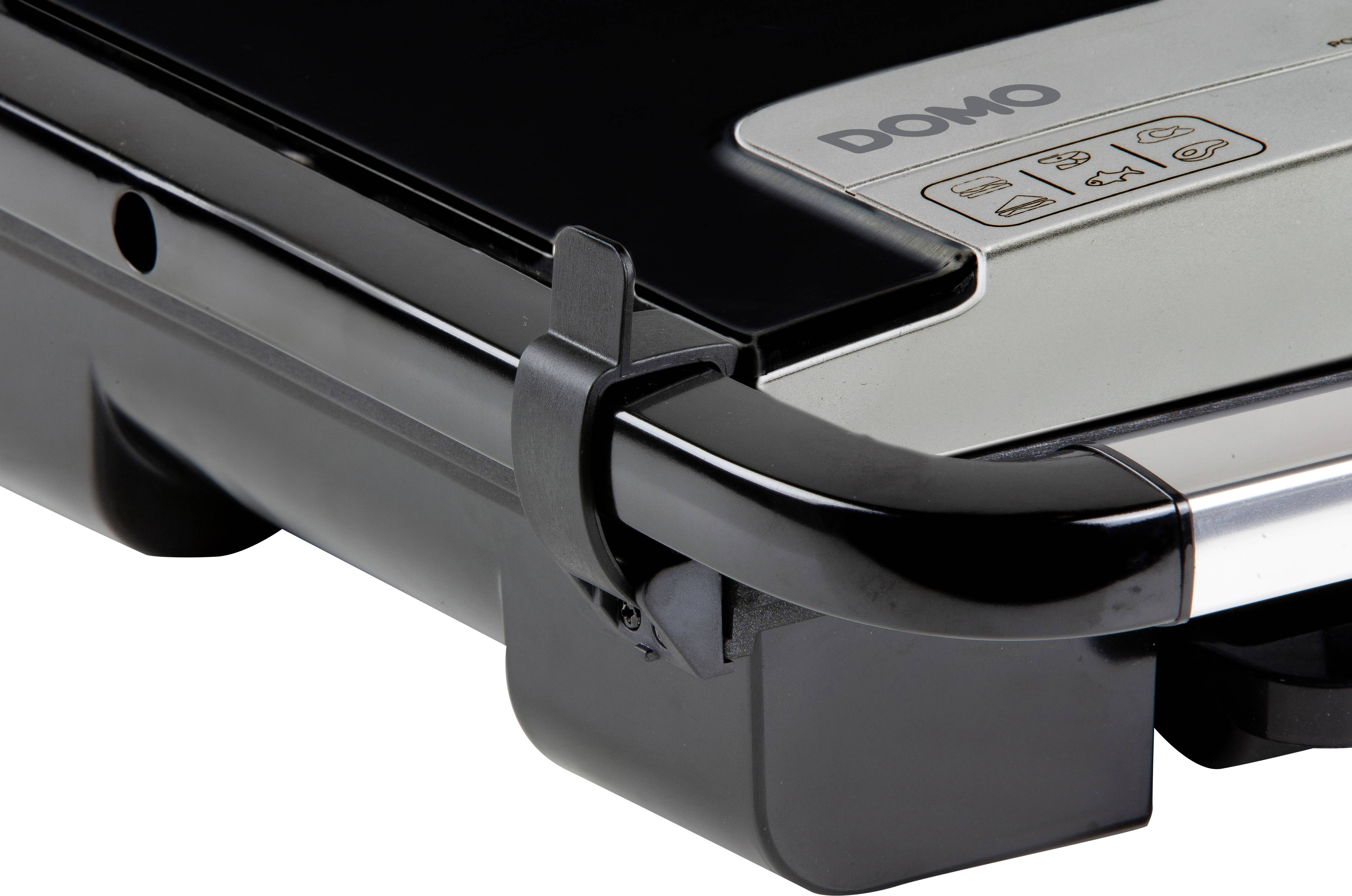 Gros plan sur un barbecue électrique au design noir et argenté, avec un verrou latéral visible et des boutons de commande en haut de l'appareil.