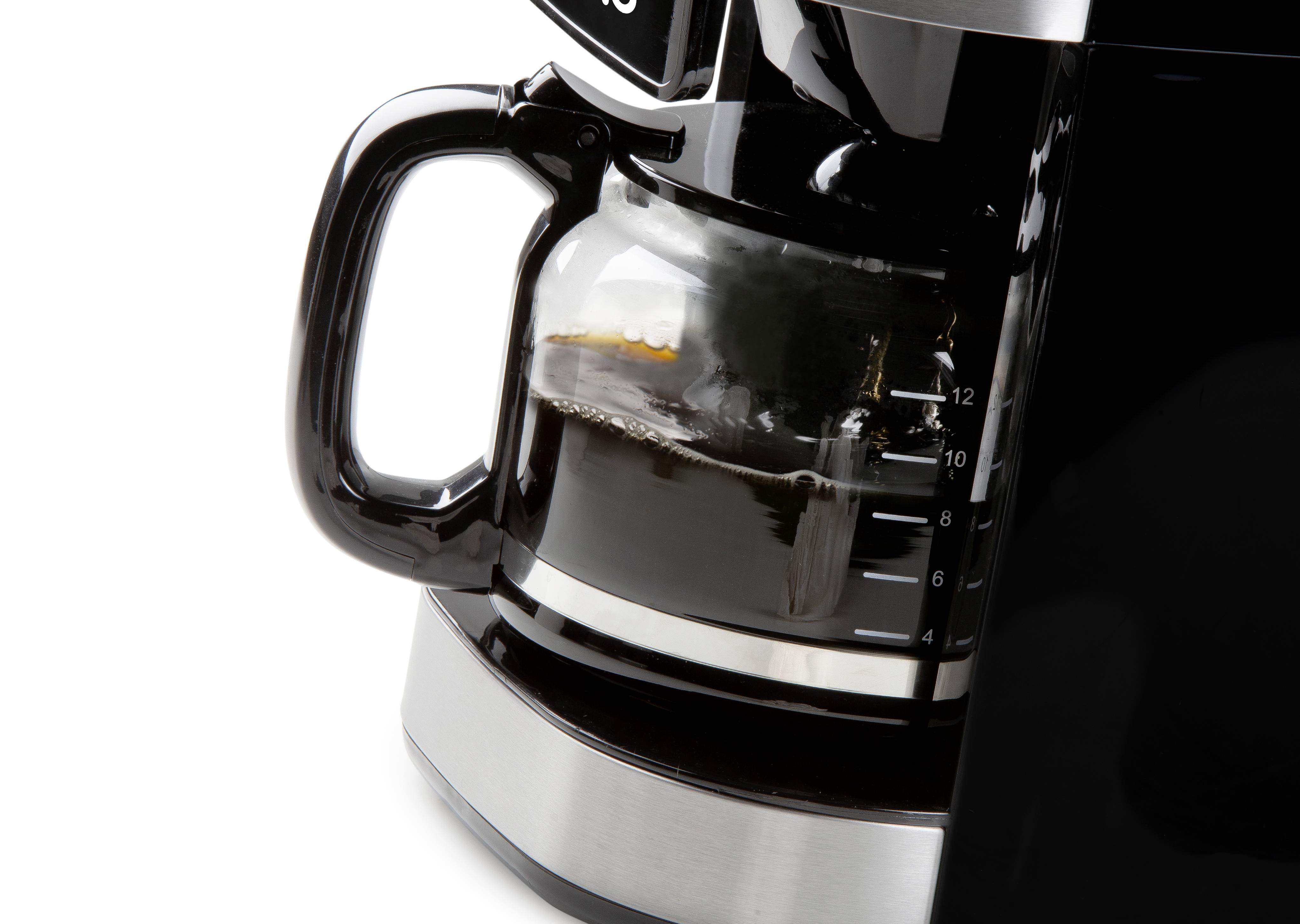 Machine à café avec un pot en verre à moitié rempli, base noire et indicateur de niveau de café visible, sur un fond blanc.