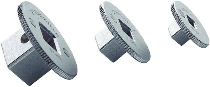 Trois roues dentées en argent de différentes tailles, avec des découpes carrées au centre, disposées en biais.