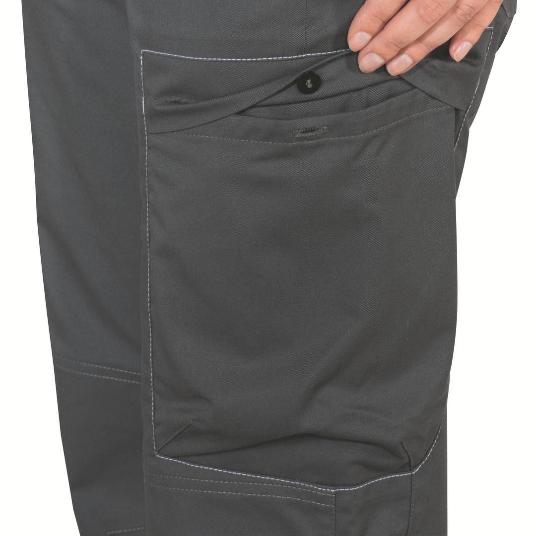 Une main se glisse dans la poche latérale d'un pantalon gris.