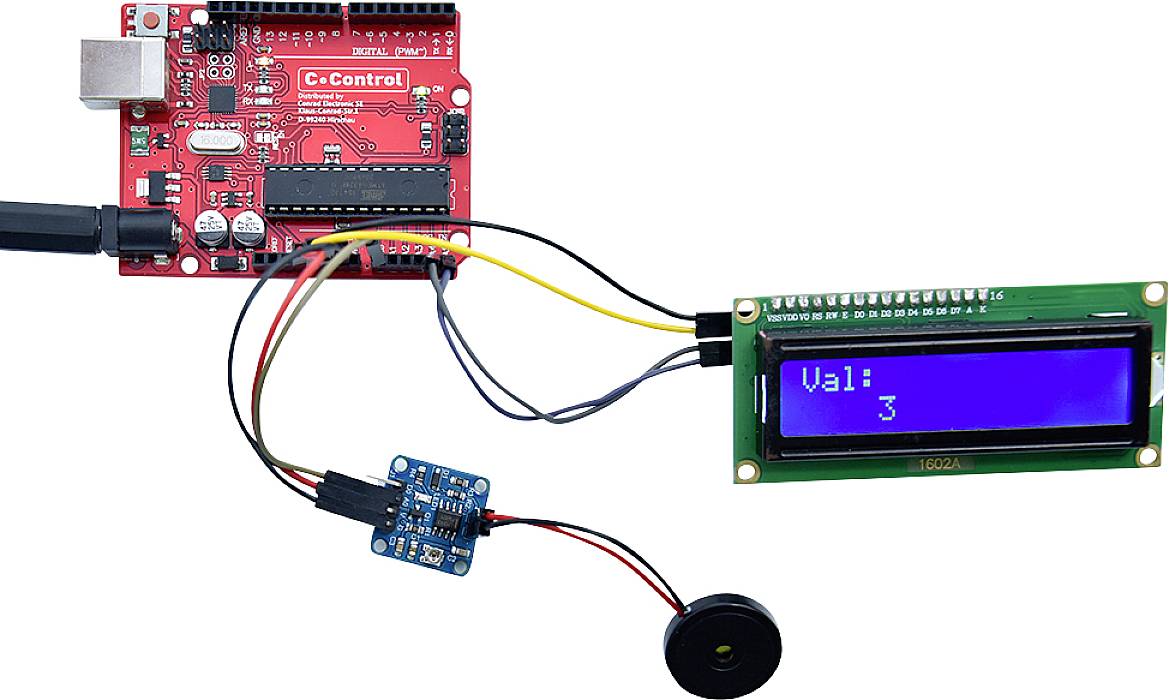 Configuration électronique d'un circuit avec une carte de microcontrôleur rouge, connectée à un écran LCD bleu, affichant 