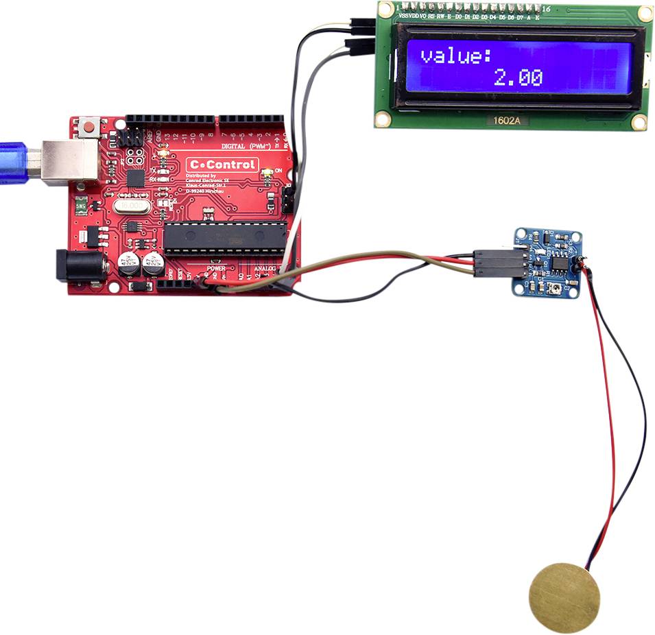 Une carte de microcontrôleur rouge est connectée à un port USB bleu. Un écran LCD affiche 'valeur : 2,00'. Un capteur est branché.