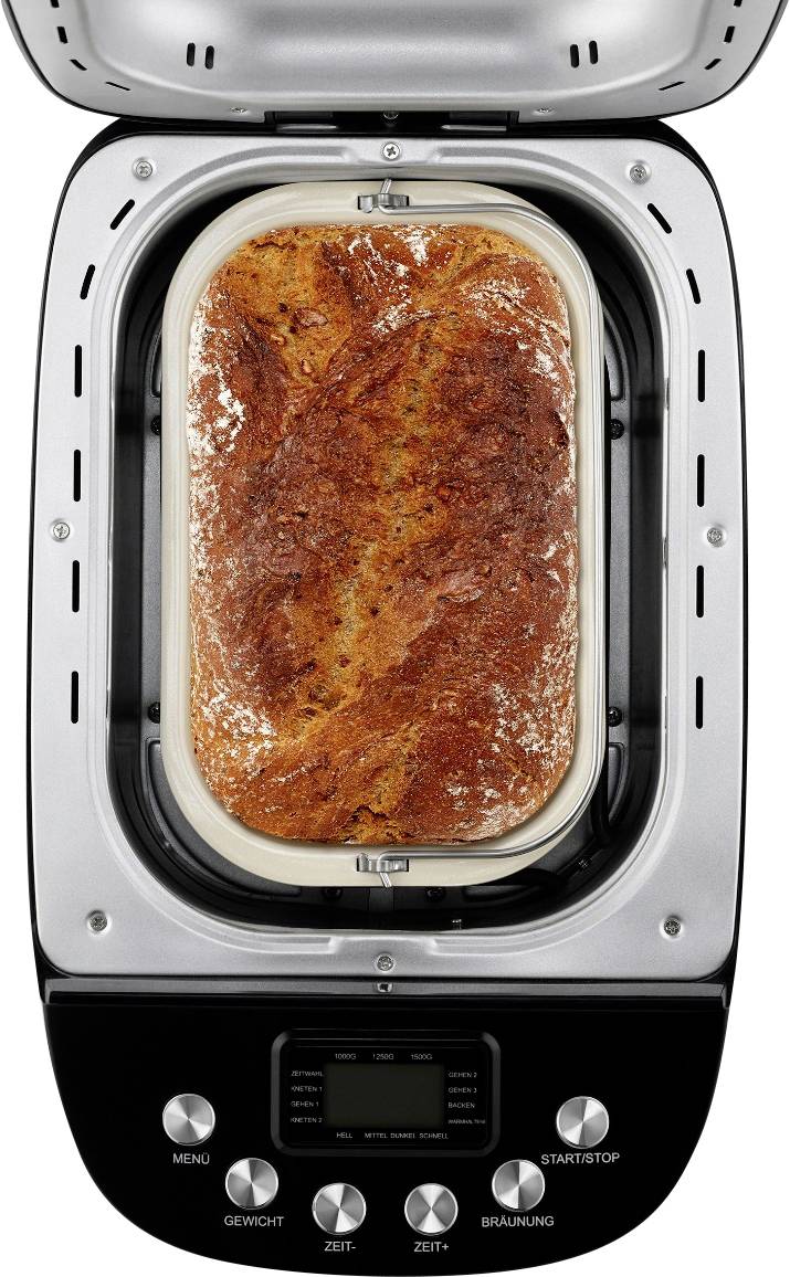 Pain frais cuit dans une machine à pain, croûte dorée et croustillante, prêt à être dégusté. Appareil équipé de commandes pour le menu, le poids, le temps et le degré de brunissement.