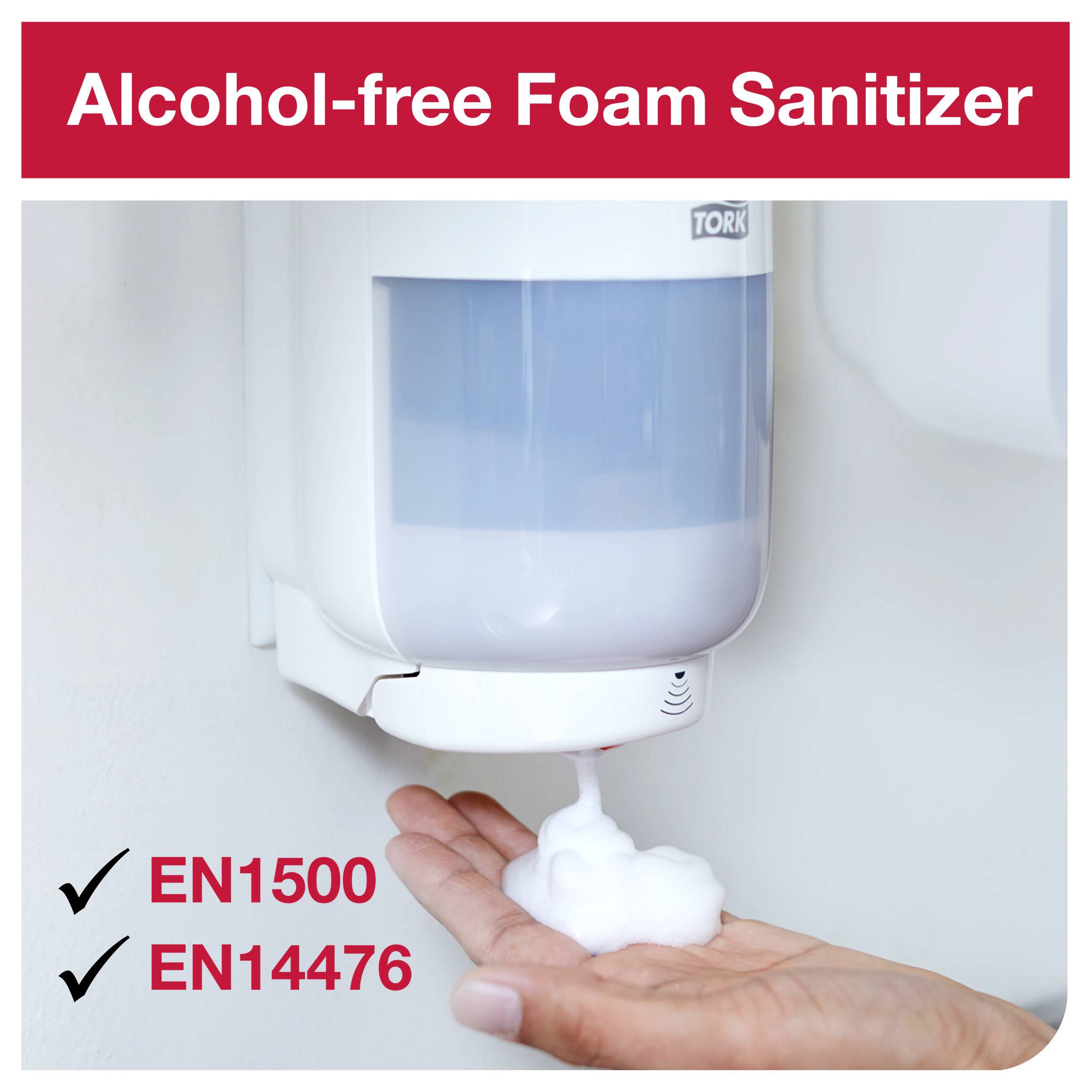 Un distributeur fournit du désinfectant pour les mains sans alcool et sans mousse. Texte en haut : 'Désinfectant Moussant Sans Alcool'. Certifications EN1500 et EN14476.