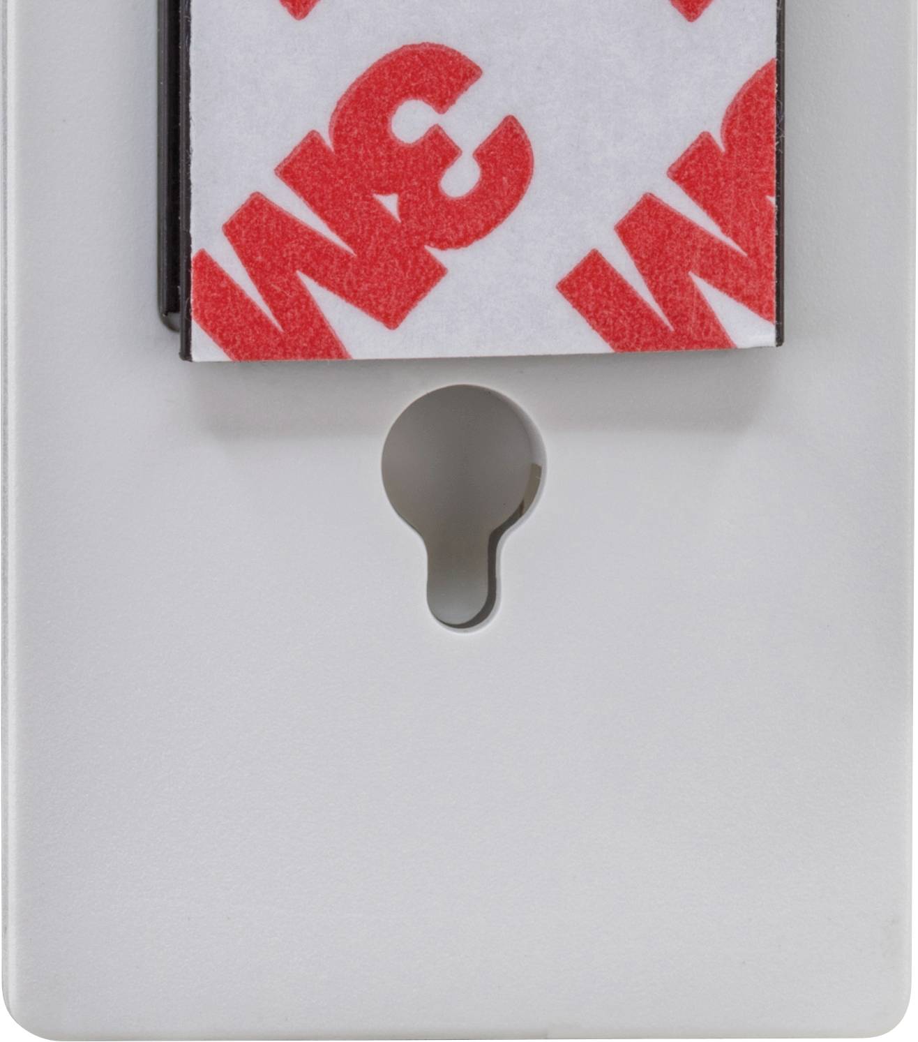 Plaque en plastique blanc avec un trou de serrure et un point adhésif rouge 3M au-dessus.