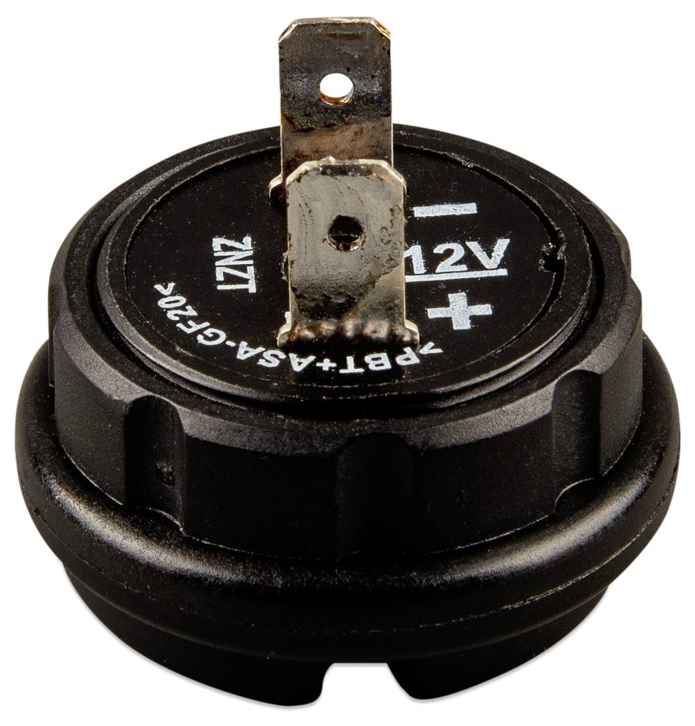 Un composant circulaire noir avec un connecteur métallique saillant, étiqueté « 12V + » sur le dessus.