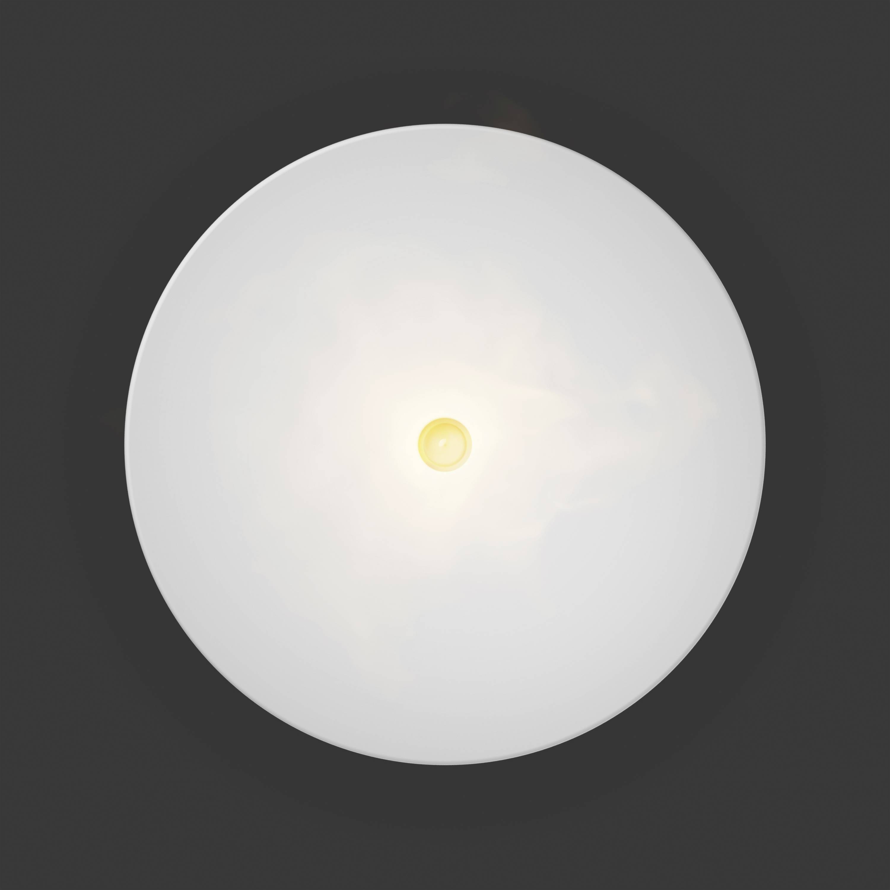 Une lampe ronde au plafond brille intensément depuis le haut, devant un fond sombre, visible au centre de l'image.