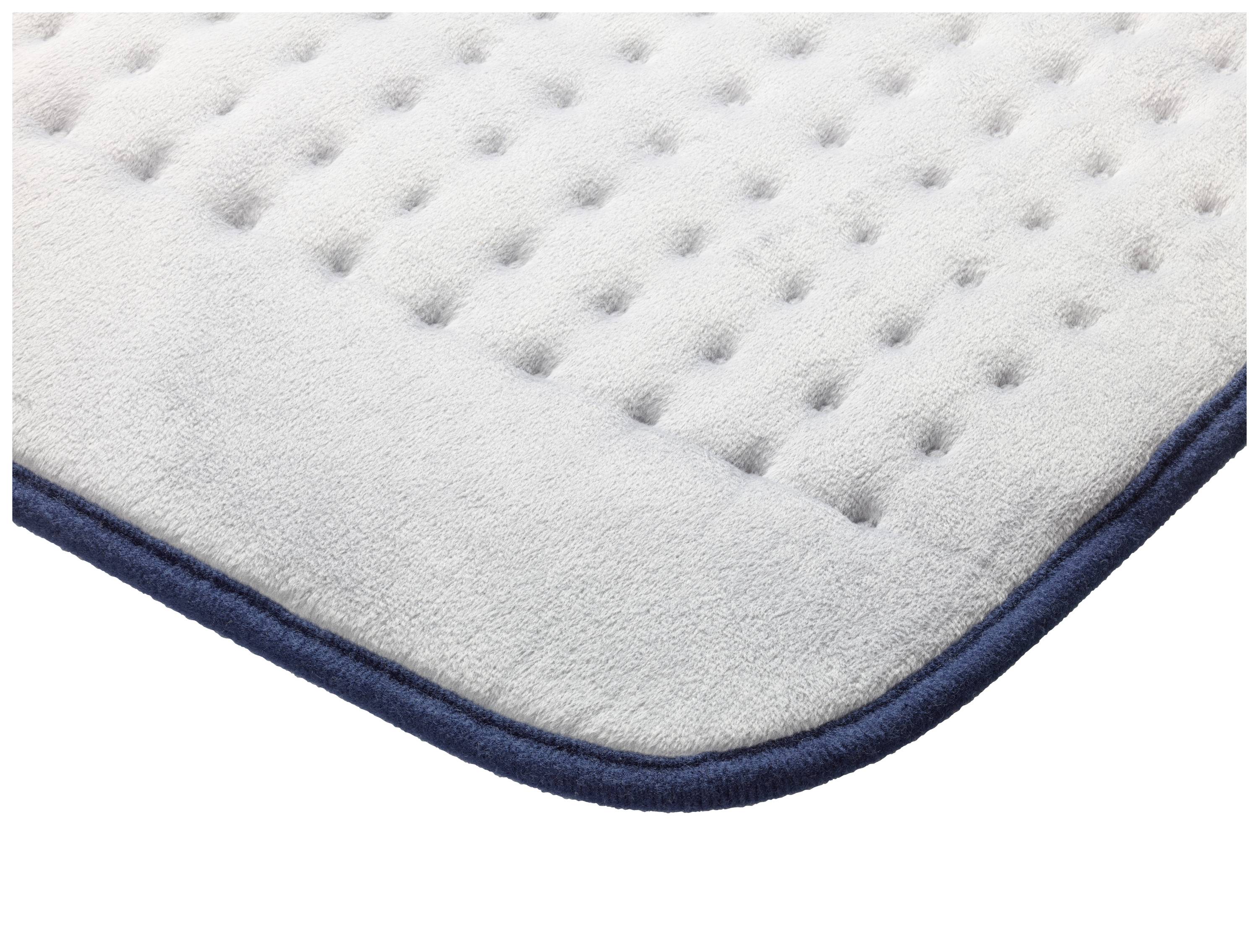 Coin d'un tapis rembourré gris clair avec une bordure bleu foncé et une structure en losanges.