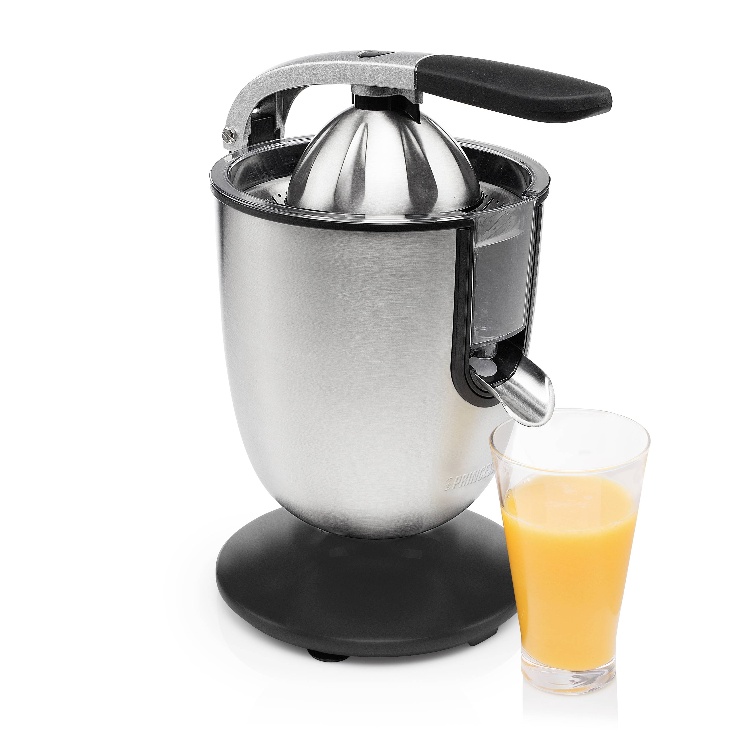 Un extracteur de jus électrique en acier inoxydable avec une poignée noire est posé sur une surface blanche. À côté se trouve un verre de jus d'orange fraîchement pressé.