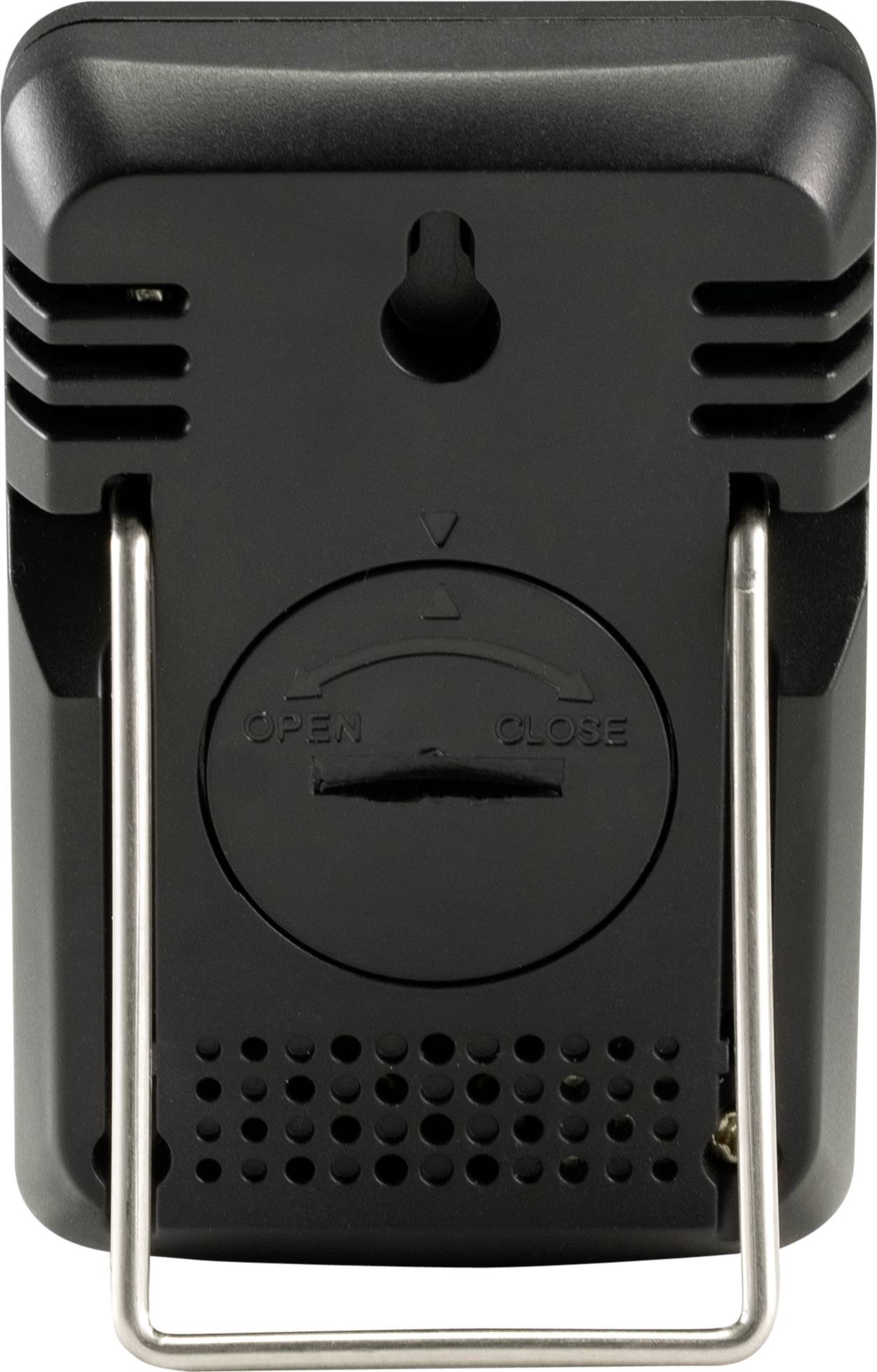 Appareil noir, rectangulaire, muni d'un dispositif de suspension et de fentes d'aération, présentant un couvercle de batterie avec des marquages indiquant le sens de l'orientation.