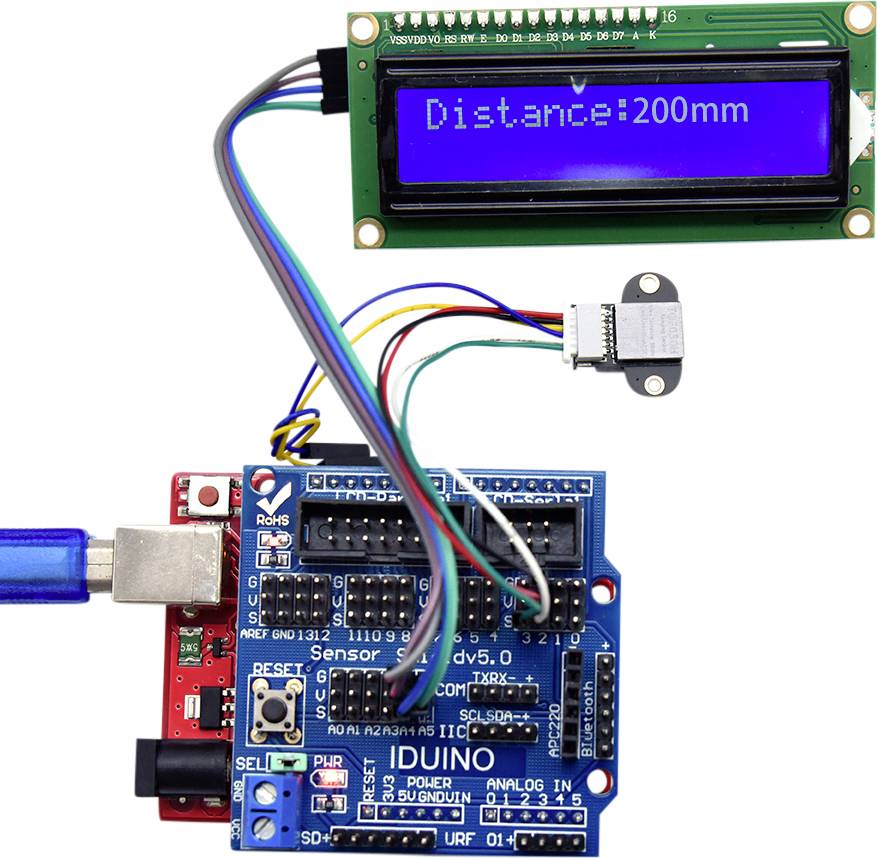 Carte Arduino avec un capteur à ultrasons connecté et un écran affichant la distance '200 mm'.