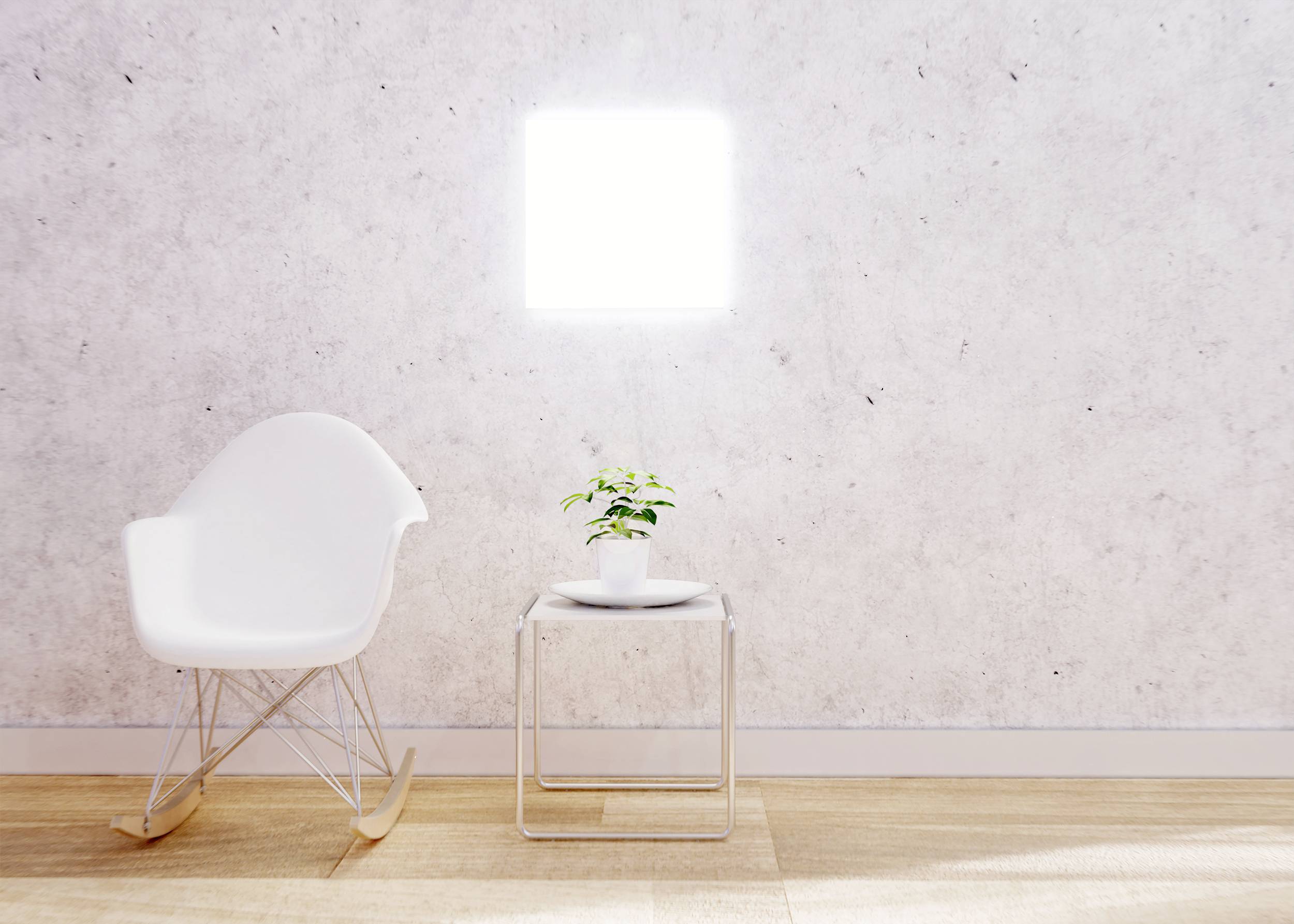 Un fauteuil à bascule blanc et une petite table avec une plante en pot devant un mur clair dans une pièce minimaliste.