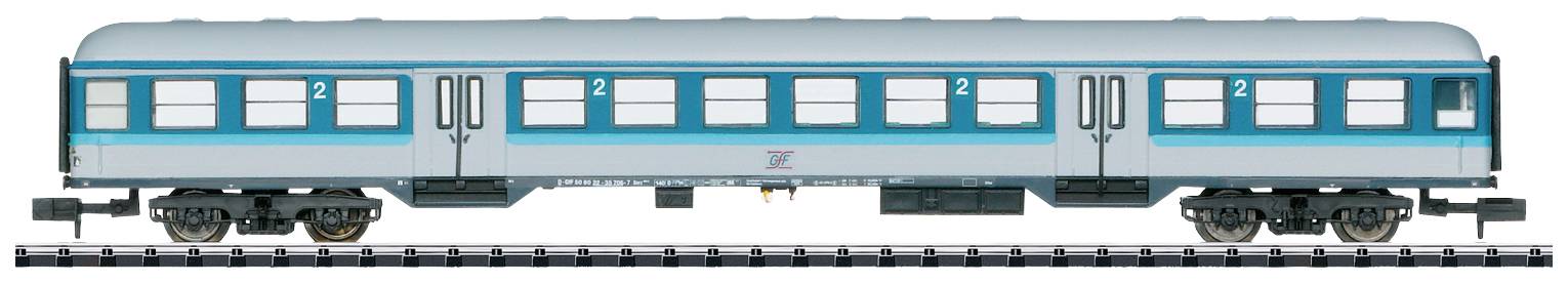 Un wagon d'argent avec des bandes bleues, portant le numéro '2' indiquant la deuxième classe, stationné sur une voie ferrée.