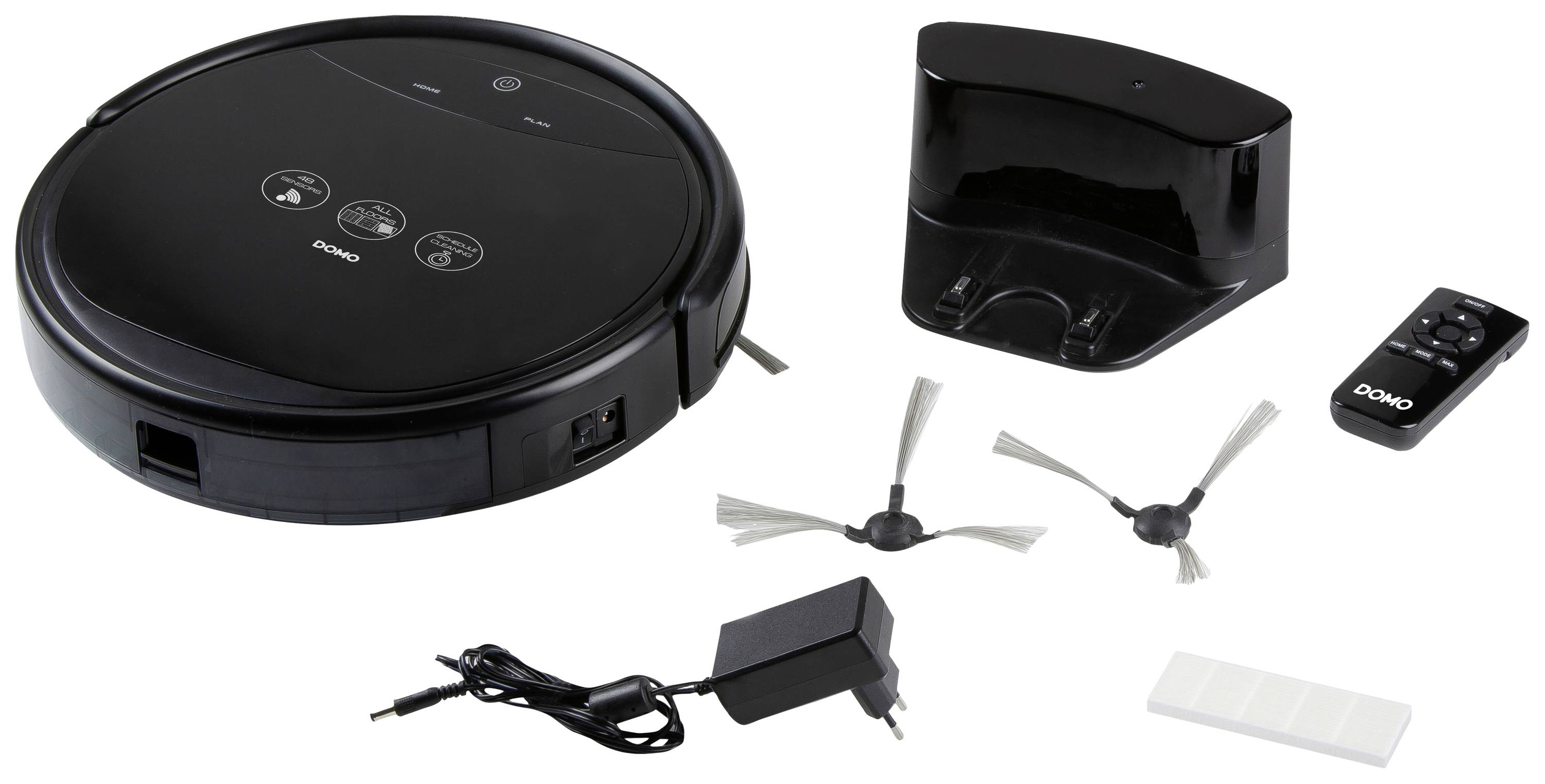 Un robot aspirateur noir avec station de charge, télécommande, deux brosses et un chargeur est posé sur un fond blanc.