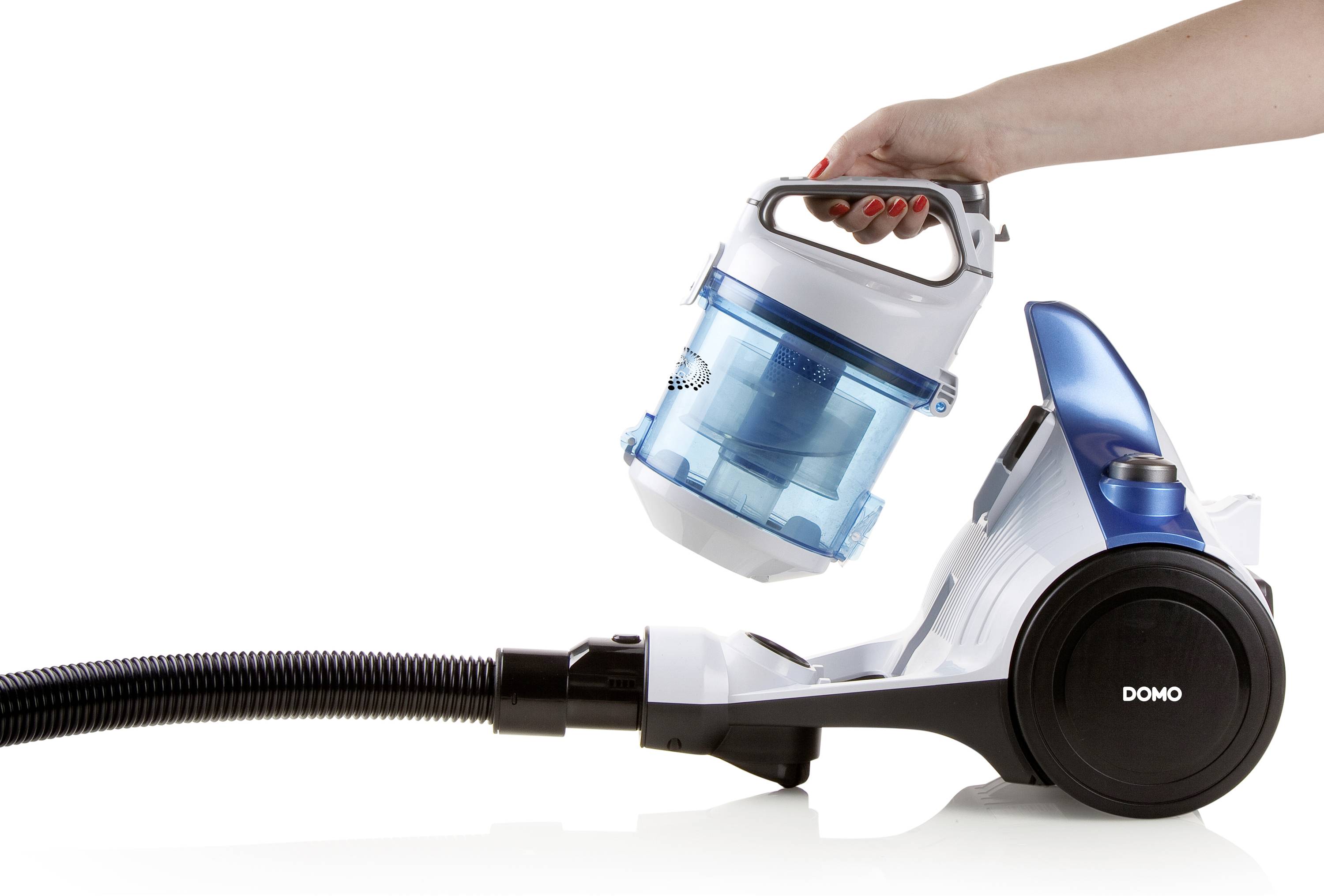 Une main retire le bac à poussière bleu d'un aspirateur blanc. L'aspirateur est équipé d'un tuyau noir et de roues.