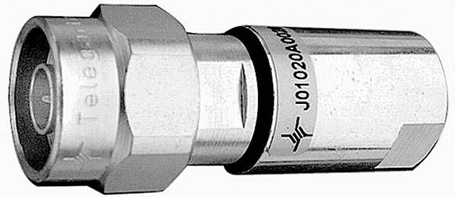 Un connecteur coaxial à surface métallique, vu de côté. Des inscriptions sont visibles, mais ne contiennent aucun détail lisible.