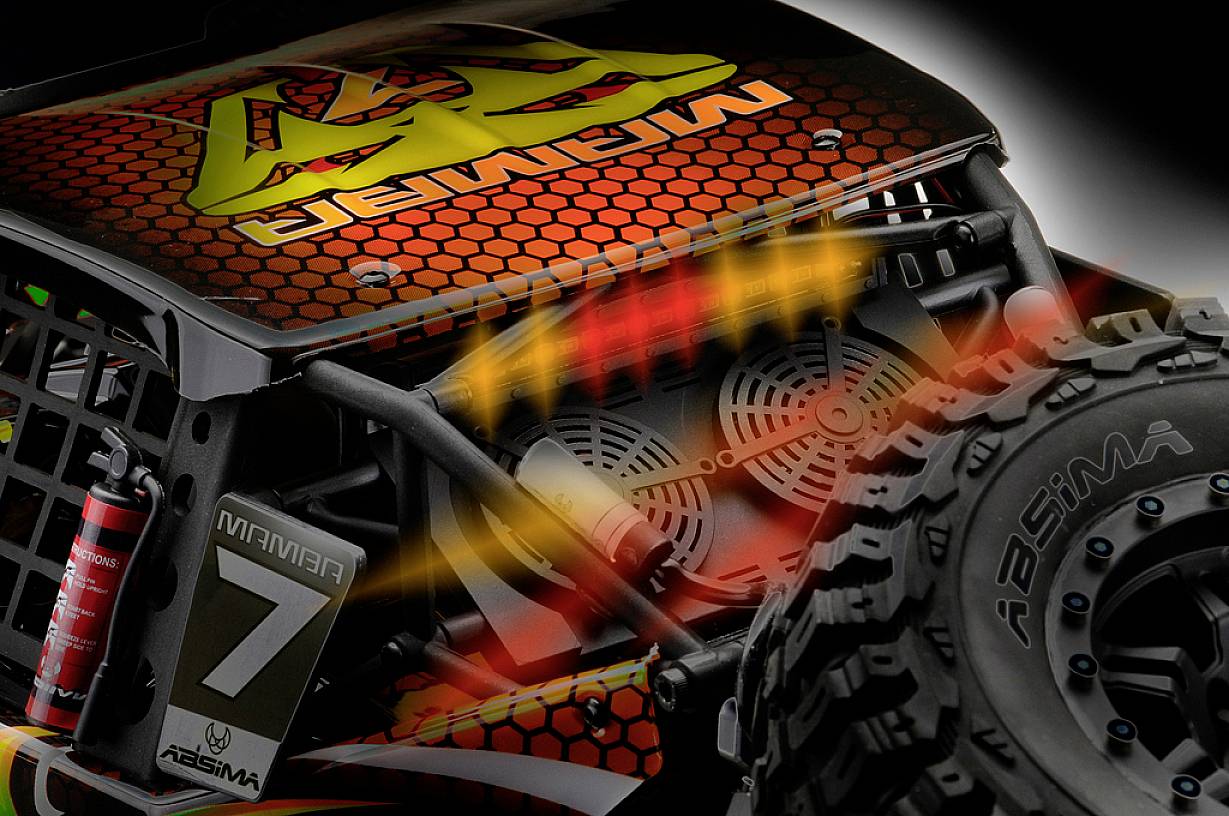 Gros plan d'une voiture télécommandée. On y voit un châssis robuste, un profil de pneu rugueux et des traînées de mouvement orange et jaune vif.