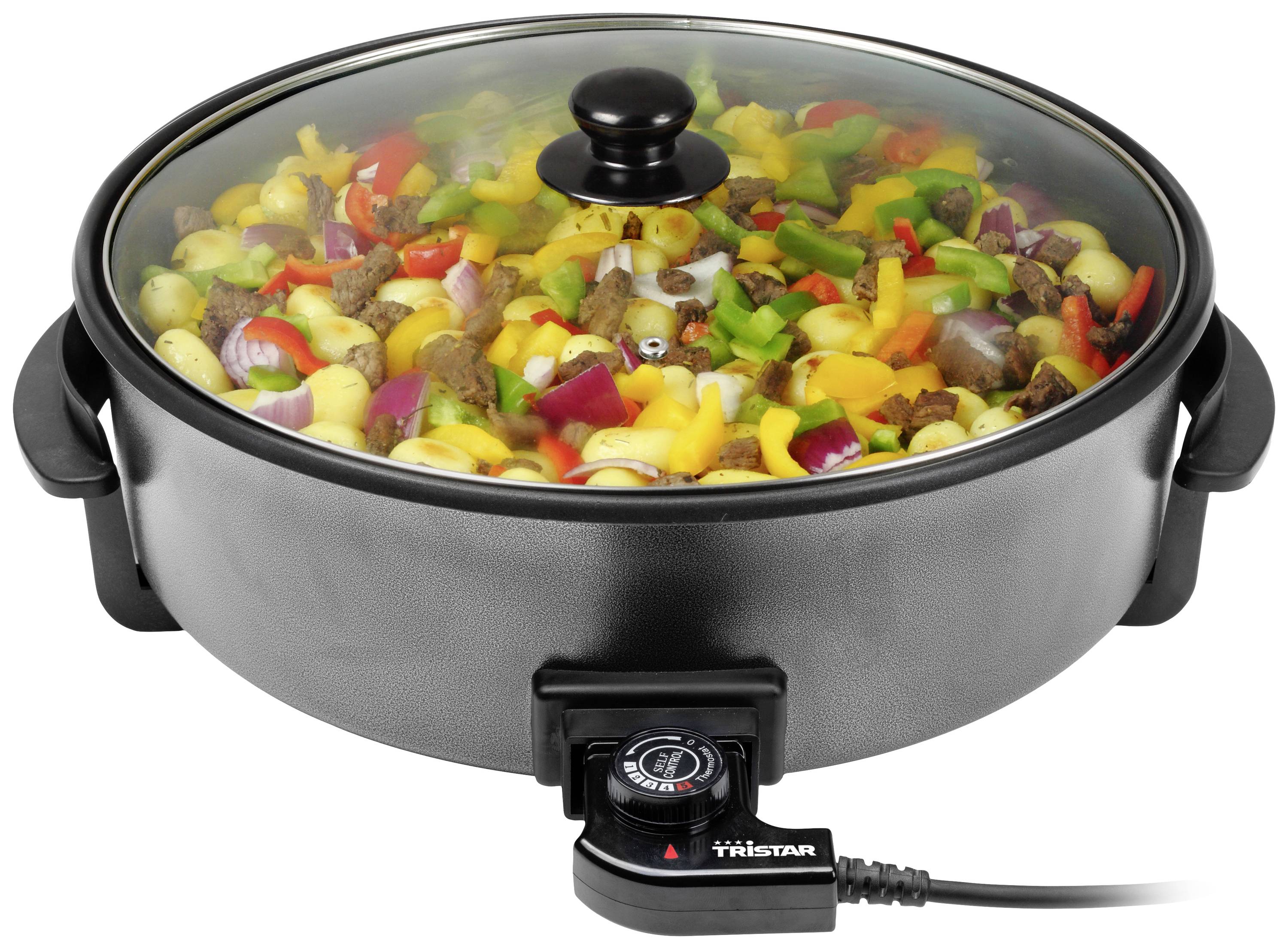 Poêle électrique ronde avec légumes et viande, couvercle en verre avec poignée, régulateur de température à l'avant.