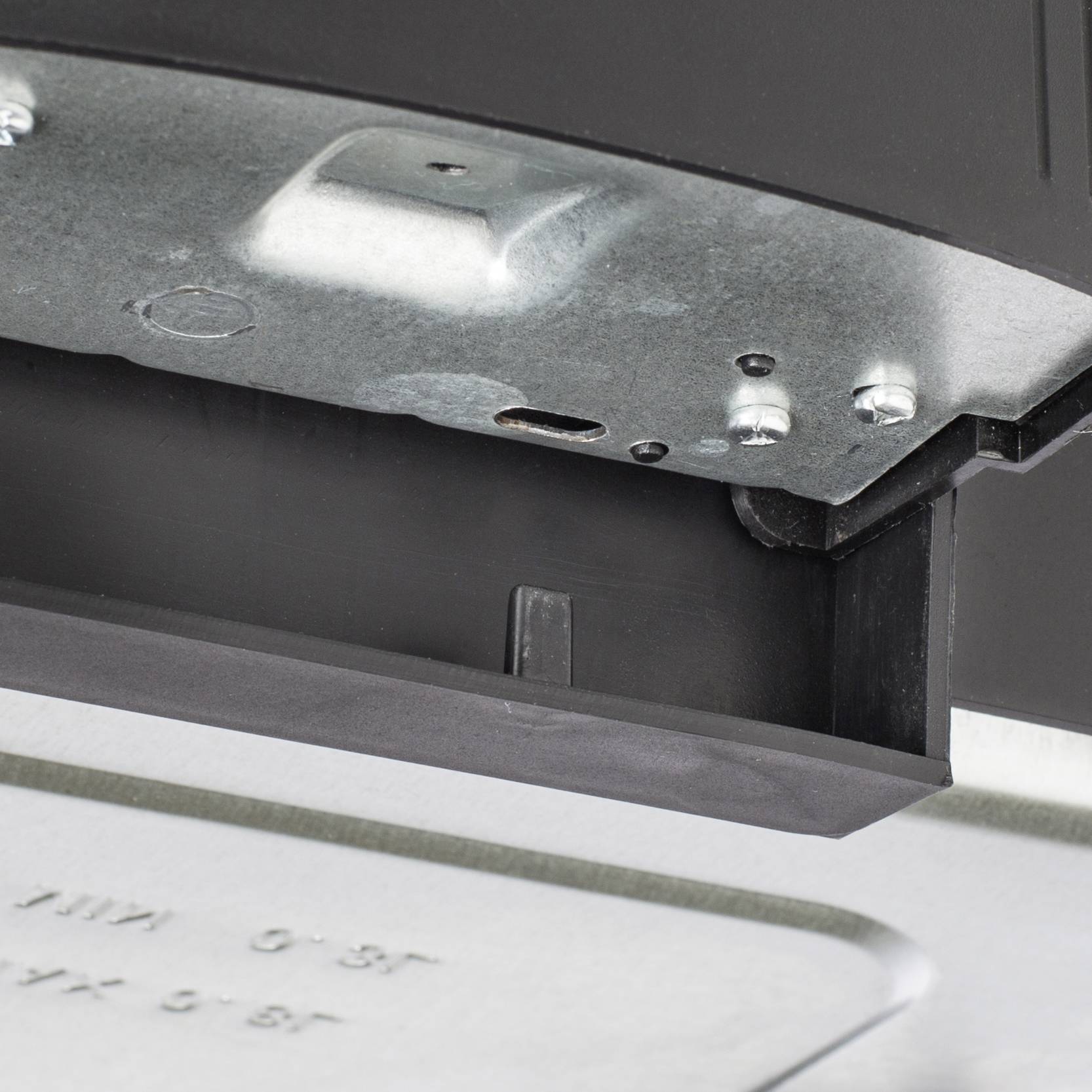 Pièce métallique avec des vis et des angles en gros plan. Vue détaillée d'un objet potentiellement technique ou mécanique.