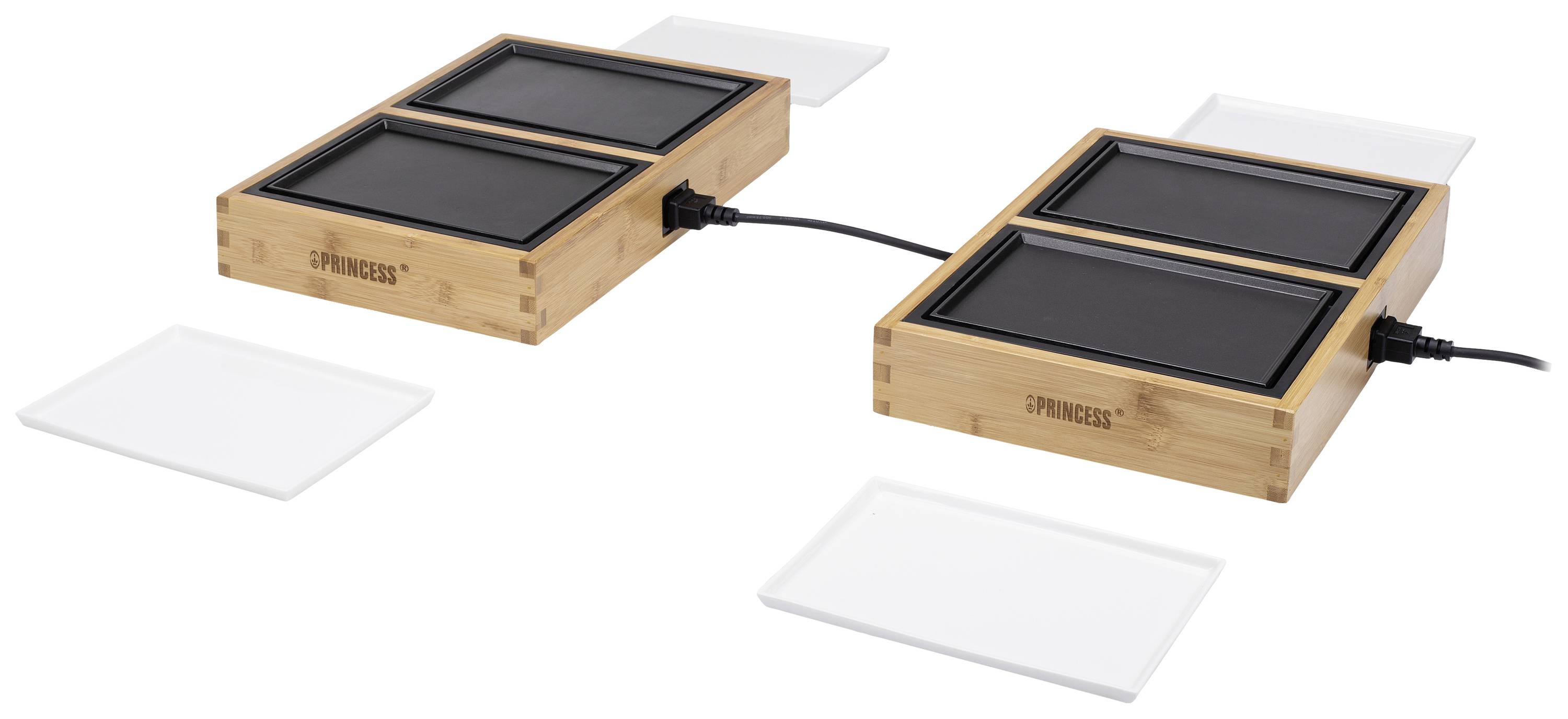 Deux plaques chauffantes électriques en bambou, chacune dotée de deux surfaces de chauffe carrées noires, reliées par un câble, entourées de assiettes blanches.