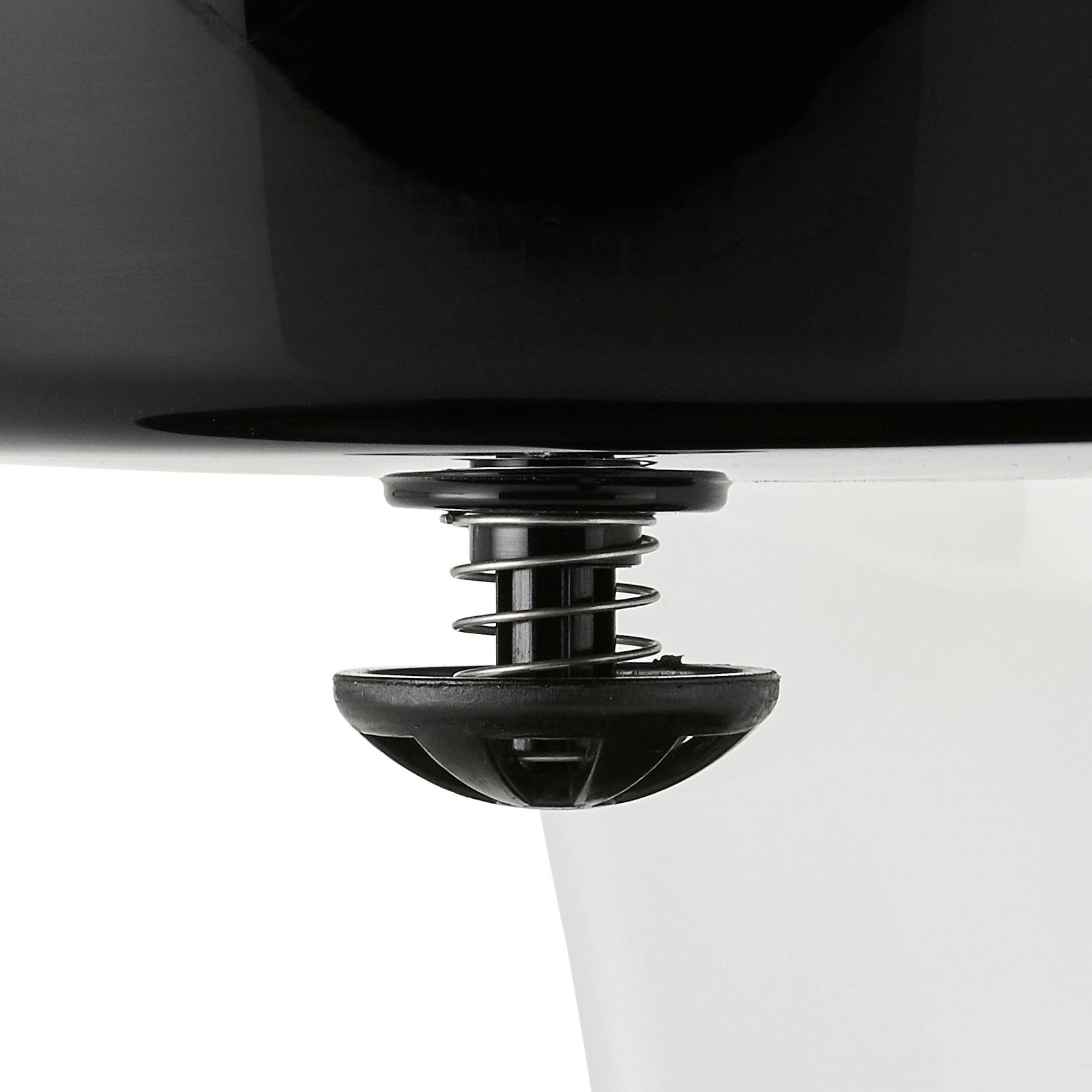 Un bouchon de vidange noir dans un lavabo blanc, partiellement ouvert, illustre la fonctionnalité de drainage ou de rétention de l'eau.