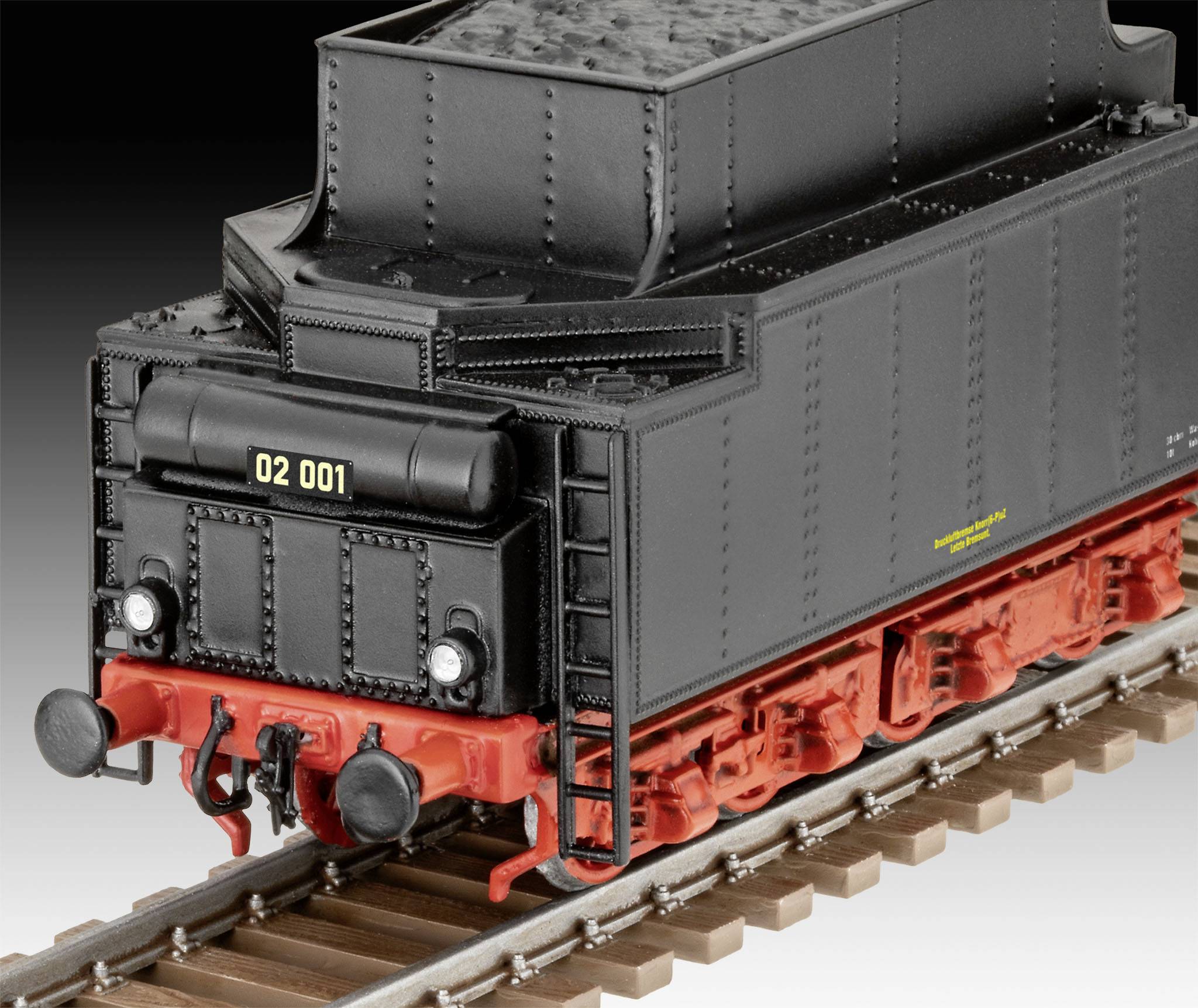 Un modèle de locomotive à vapeur noir avec un tender et un châssis rouge sur des rails, portant le numéro '02 001' à l'arrière.