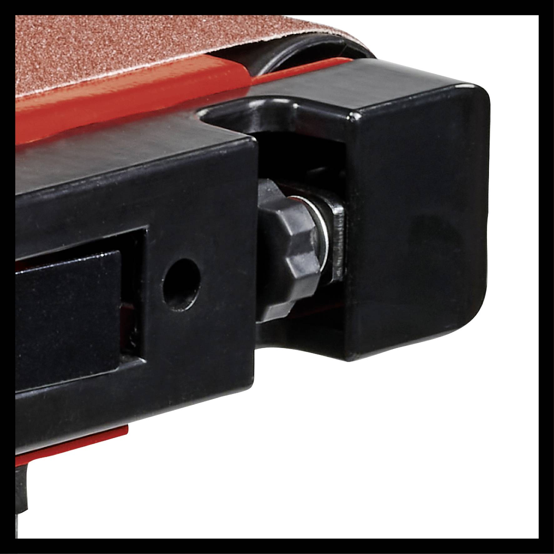 Gros plan d'une bande de ponçage d'une machine. Le cadre noir et le caoutchouc rouge sont clairement visibles. Mise au point sur la mécanique.