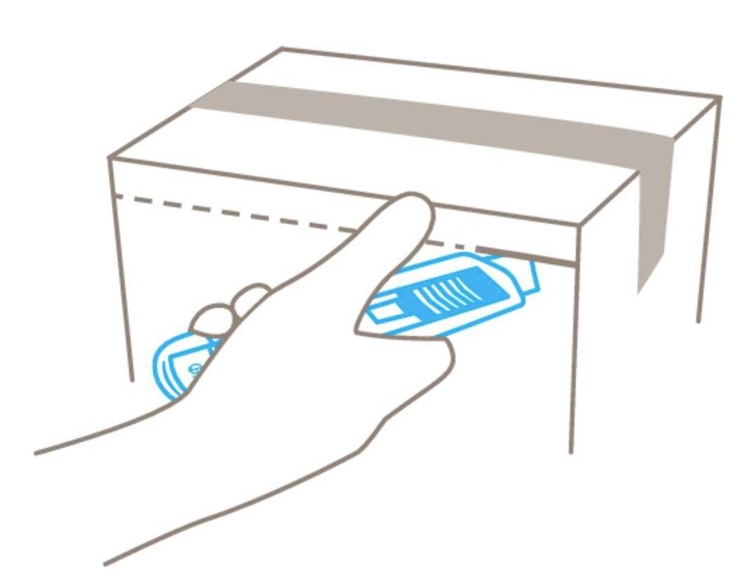 Une main dépose une boîte depuis le bas dans un carton avec une ouverture sur le couvercle.