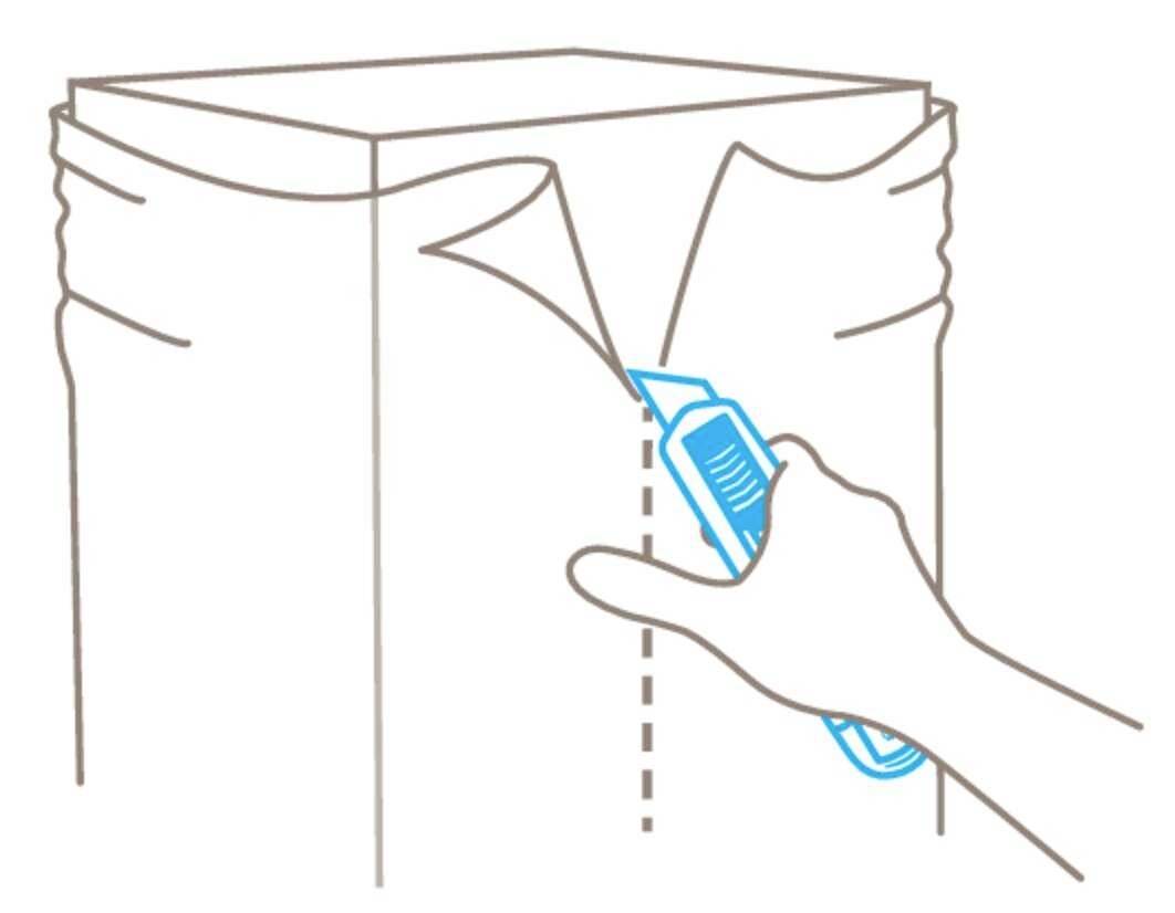 Une main coupe le dessus d'un carton avec un cutter, le long d'une ligne pointillée, pour l'ouvrir.