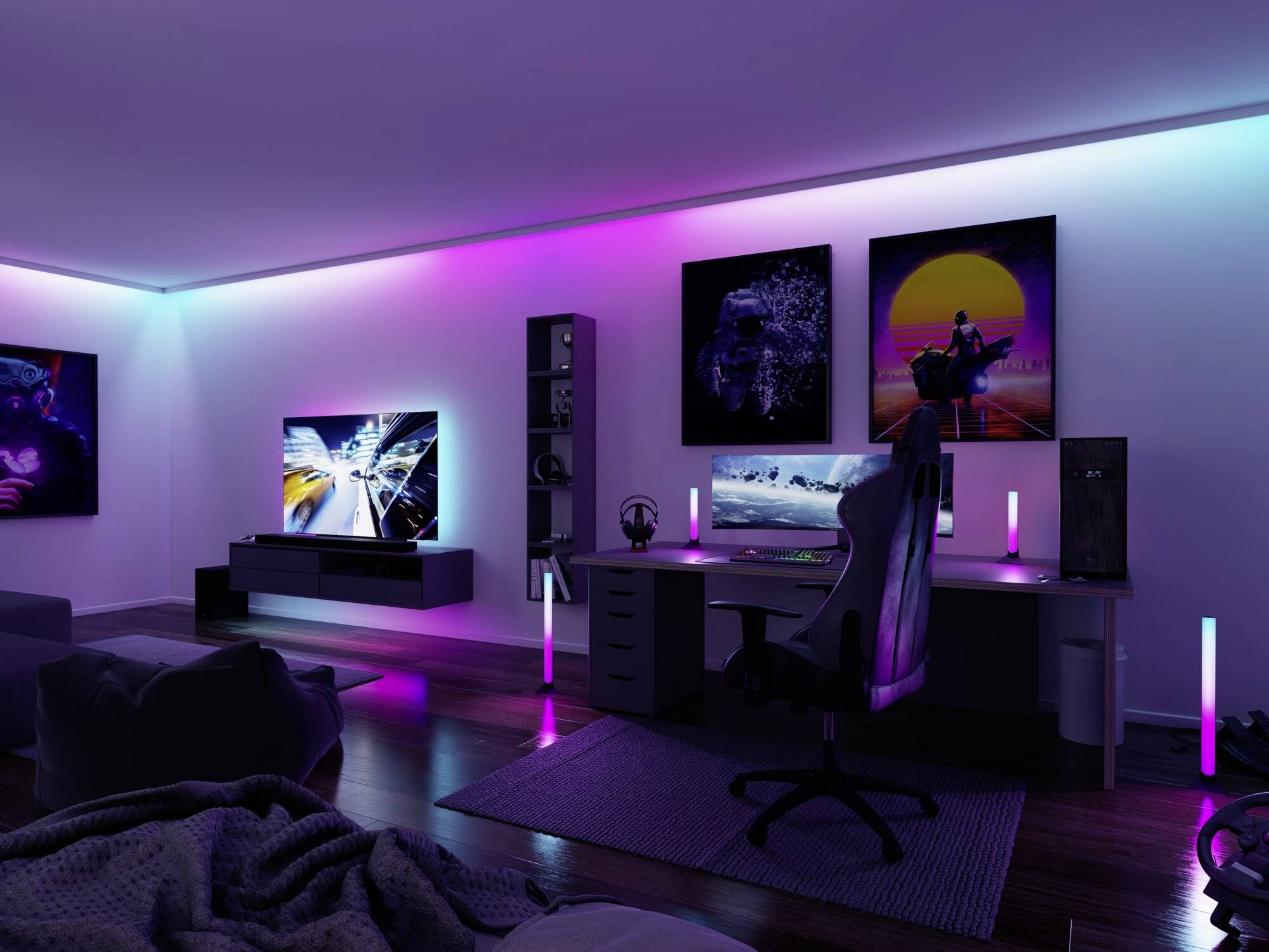Chambre de gaming avec éclairage RVB, grand écran, configuration PC sur un bureau et fauteuil confortable, posters décoratifs au mur.