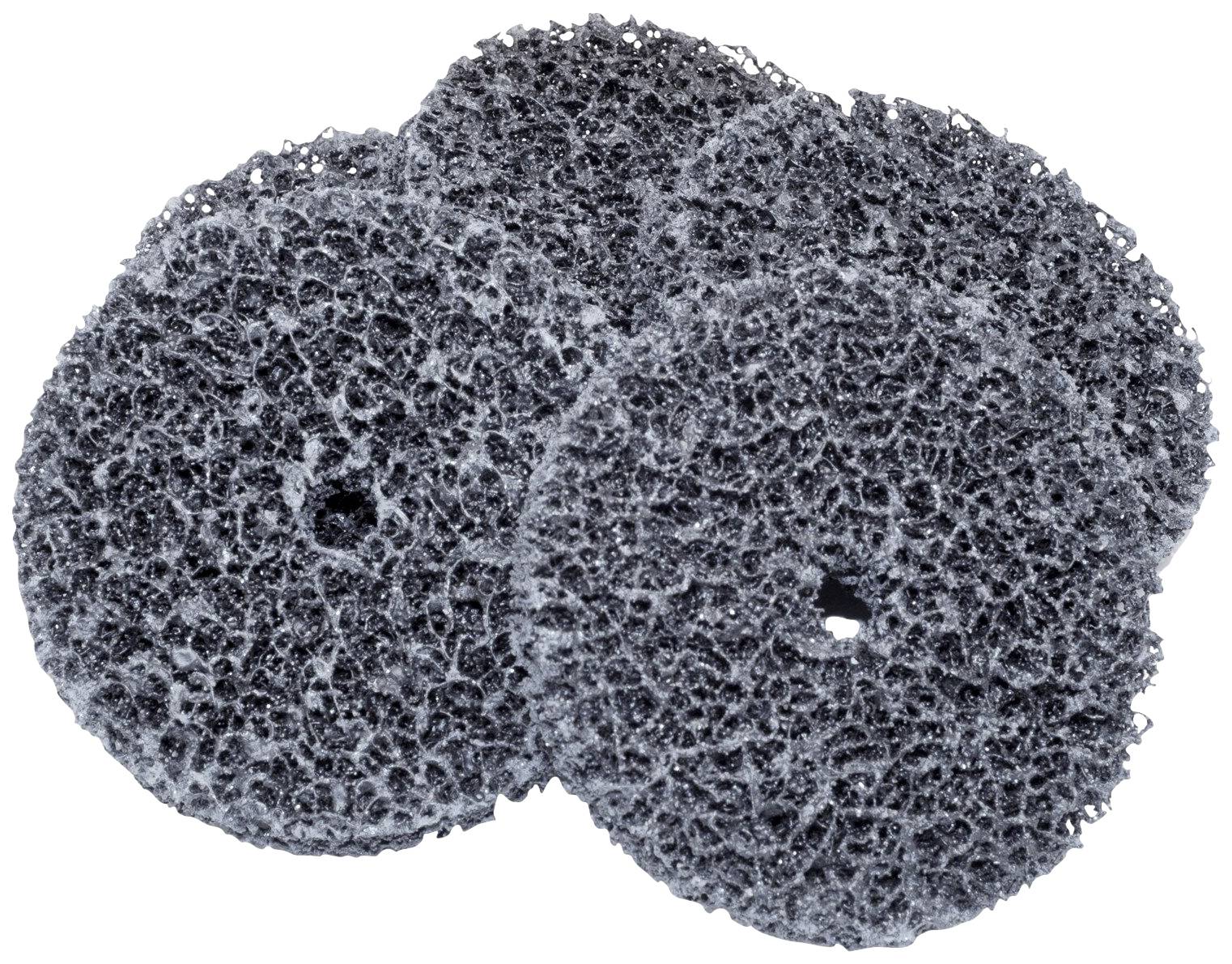 Trois éponges à récurer noires, rondes, à texture granuleuse, sont empilées les unes sur les autres.