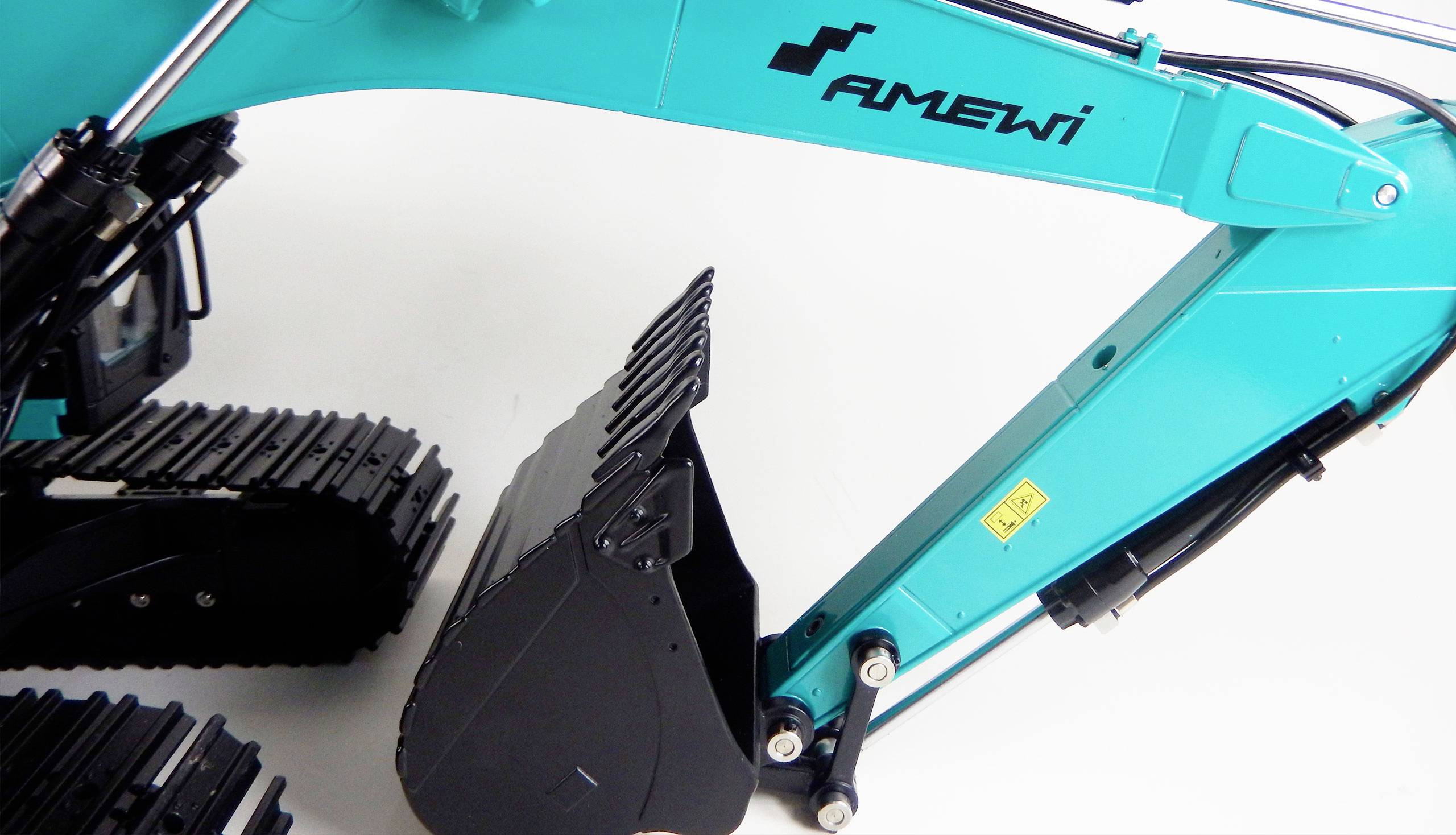 Un mini-excavateur turquoise avec un bras de pelle noir et des chenilles, sur un fond blanc.