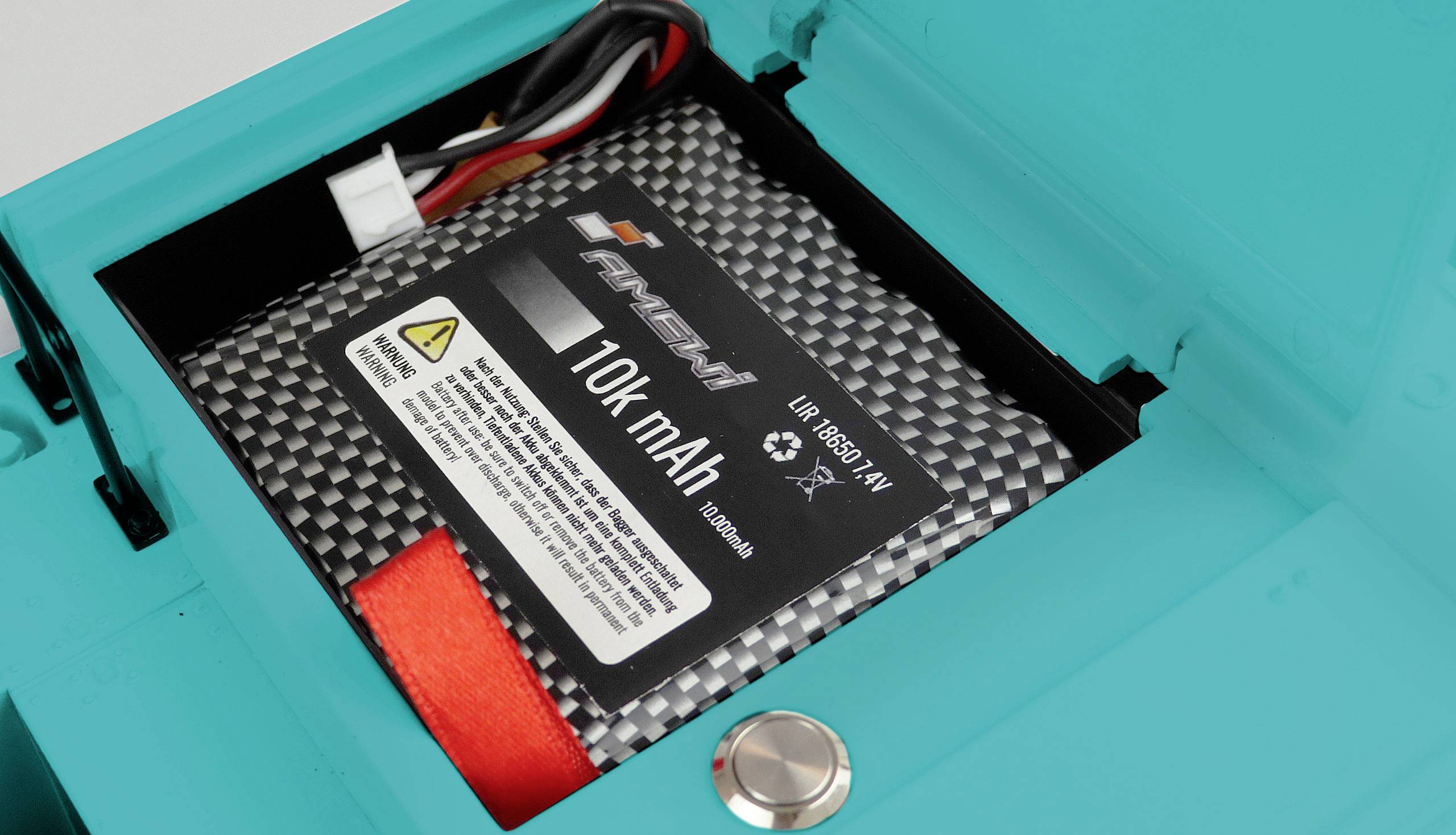 Une batterie de 10 000 mAh est logée dans un boîtier bleu. Des câbles sont visibles, et une mise en garde est inscrite sur l'étiquette de la batterie.