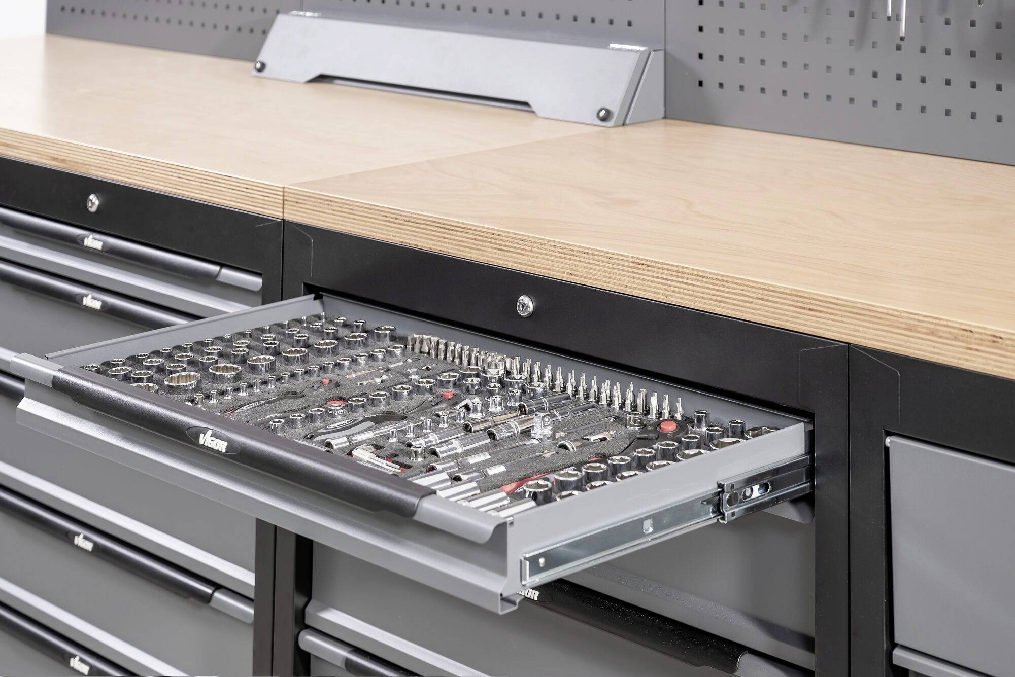 Un tiroir ouvert d'un armoire à outils révèle une variété d'outils manuels bien rangés, comprenant des clés à douille et des tournevis.