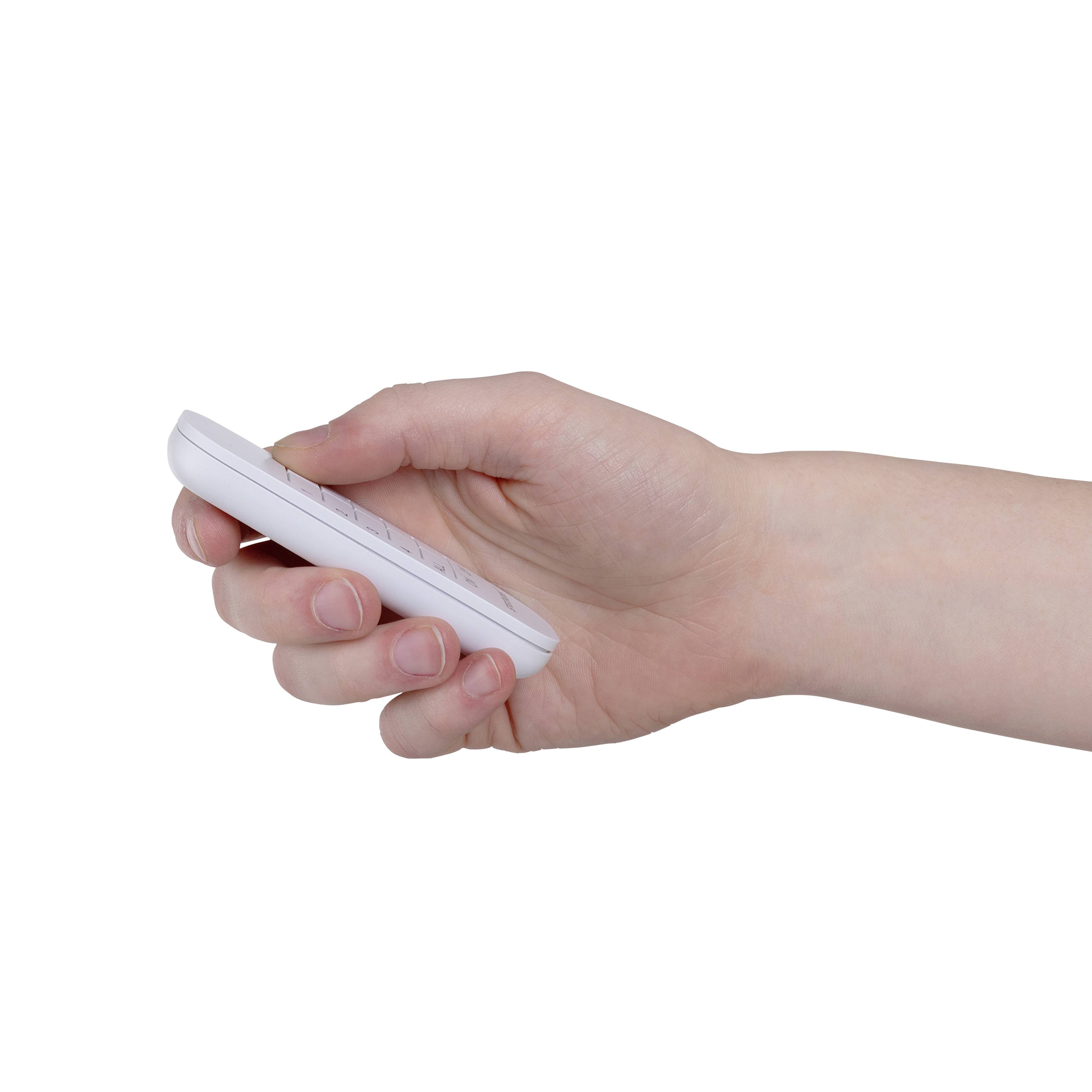 Une main tient une télécommande blanche qui pointe vers le bas.