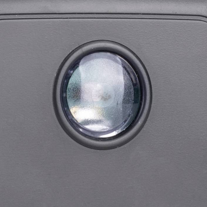 Objectif noir d'un appareil photo sur un dispositif gris, ne montrant aucun autre contexte ou fonction.