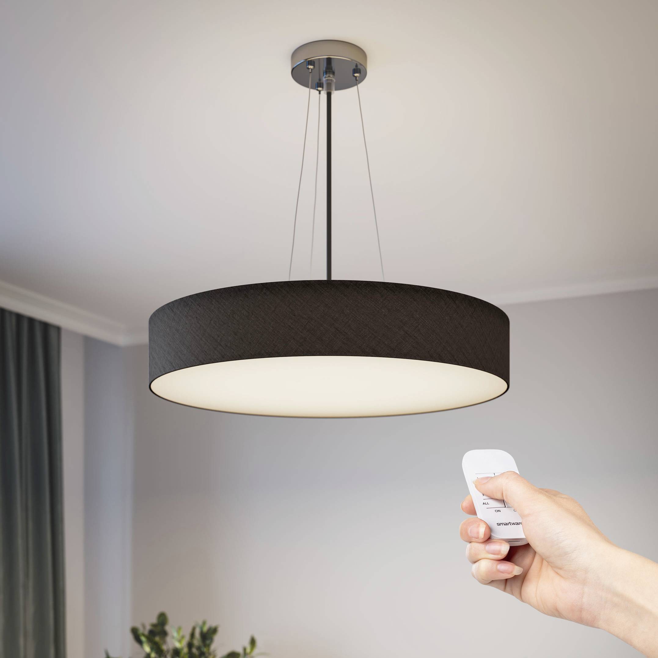 Un luminaire moderne suspendu au plafond est commandé par télécommande.