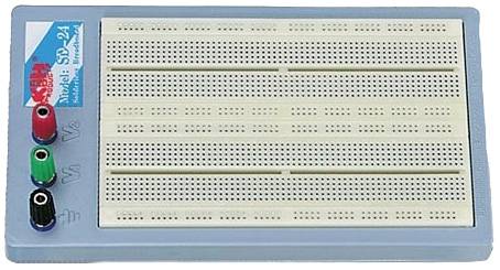 Un breadboard avec des connexions en rouge, noir et vert sur la gauche. Il est utilisé pour le développement de circuits et la création de prototypes.