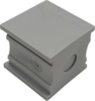 Un bloc gris métallique de forme carrée avec des ouvertures rondes sur les côtés.