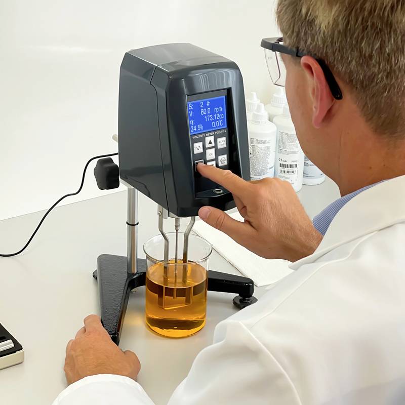 Un scientifique dans un laboratoire mesure la viscosité d'un liquide à l'aide d'un viscosimètre. La valeur de mesure est affichée sur l'appareil.