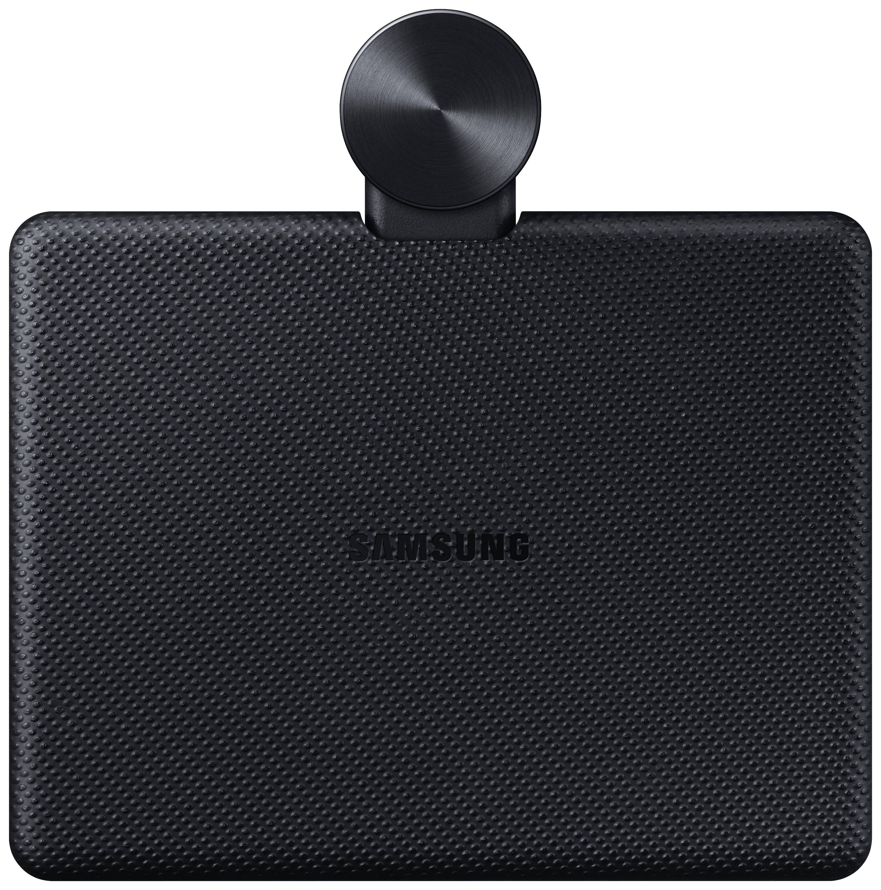 Un objet noir et structuré avec le logo Samsung et un bouton rond et plat en son centre.