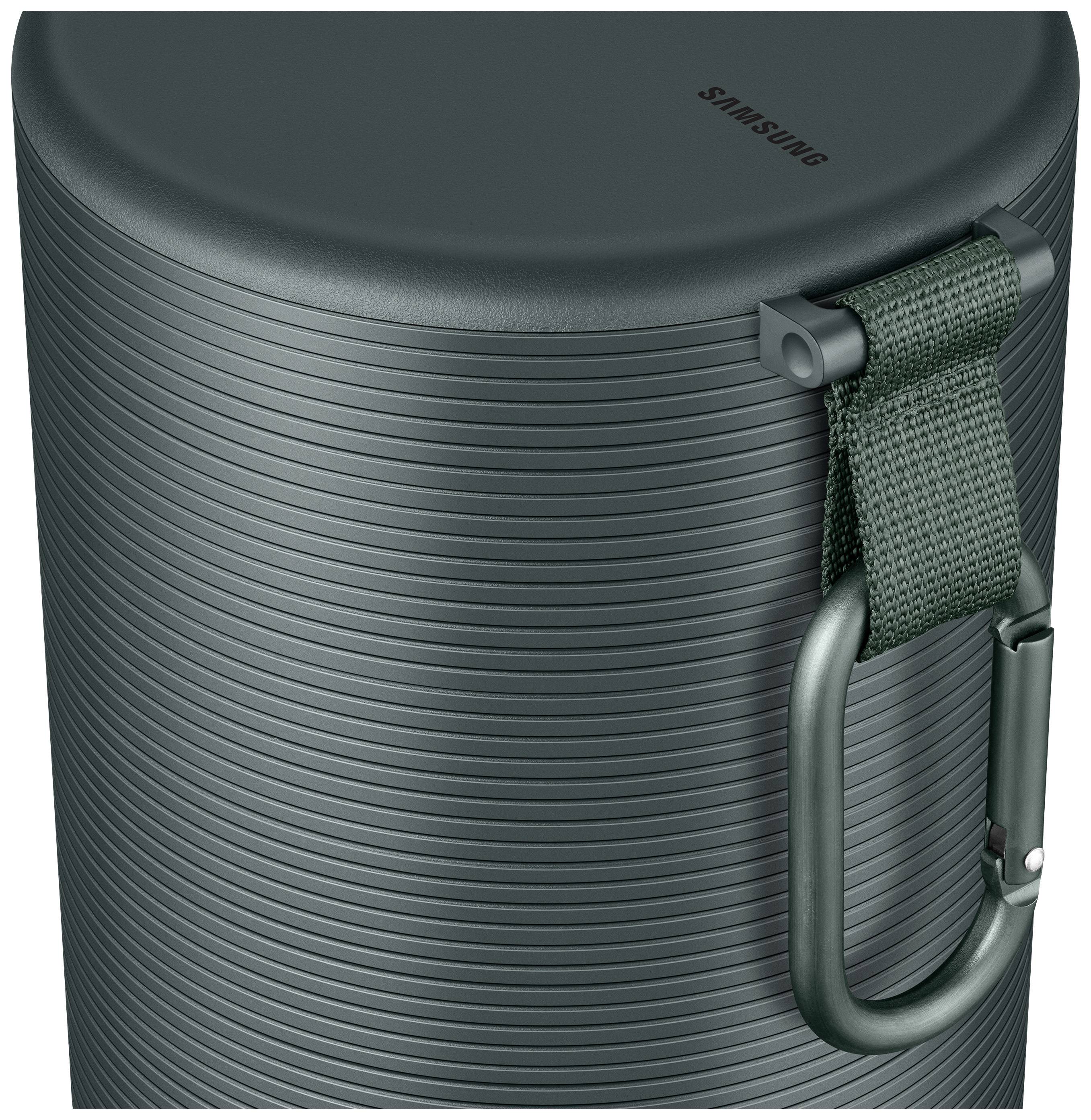 Sac à main cylindrique vert foncé avec un design côtelé, une poignée de transport et un mousqueton sur le côté, marqué du logo.