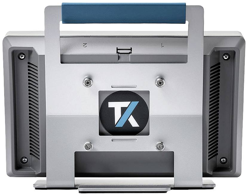Vue arrière d'un appareil électronique gris avec une poignée et un logo 'TK' au centre. L'appareil possède des fentes d'aération des deux côtés.
