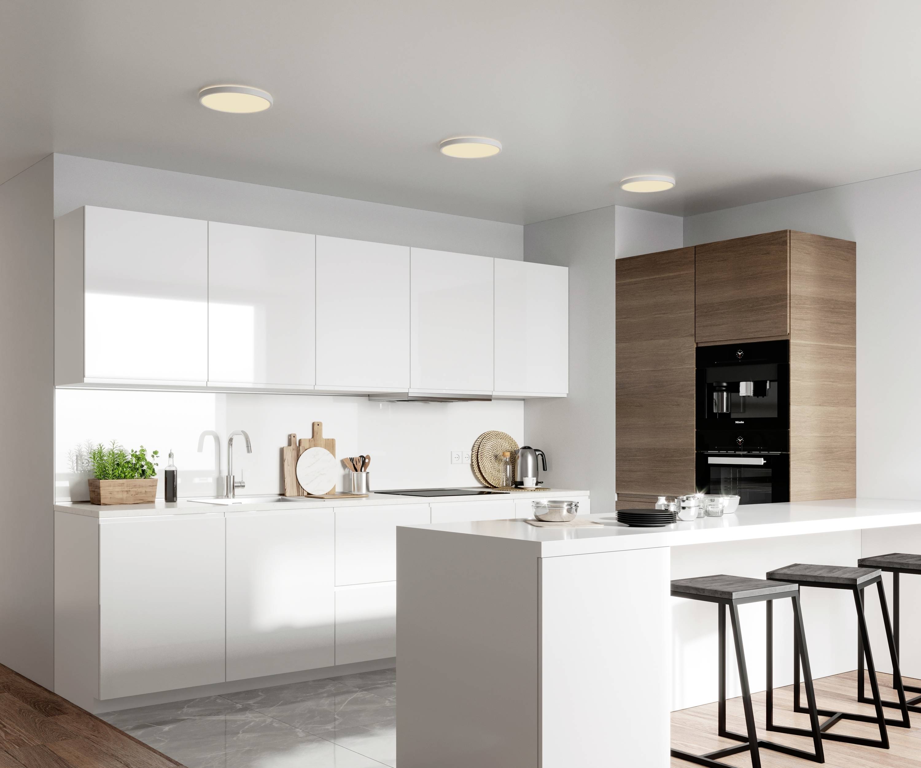 Cuisine moderne avec armoires blanches, touches de bois et tabourets de bar. Éclairage lumineux, aménagement minimaliste et design fonctionnel.